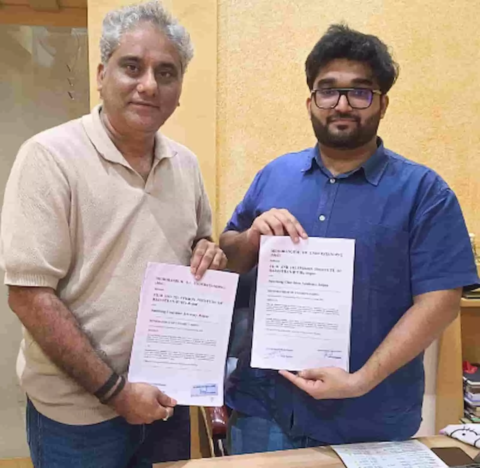 तस्वीर में सोमेंद्र हर्ष और अनमोल अग्रवाल जयपुर में एमओयू दस्तावेजों को पकड़े हुए नजर आ रहे हैं। तस्वीर में सोमेंद्र हर्ष और अनमोल अग्रवाल जयपुर में एमओयू दस्तावेजों को पकड़े हुए नजर आ रहे हैं।