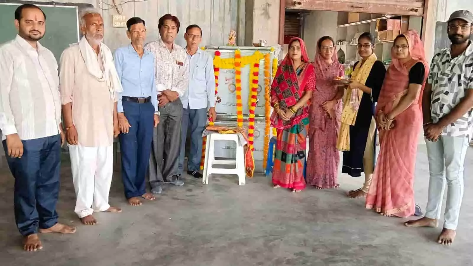 तस्वीर में दिख रहे लोग भुसावर के स्कूल में फूलों की माला से सजे वाटर कूलर के पास खड़े हैं. तस्वीर में दिख रहे लोग भुसावर के स्कूल में फूलों की माला से सजे वाटर कूलर के पास खड़े हैं.