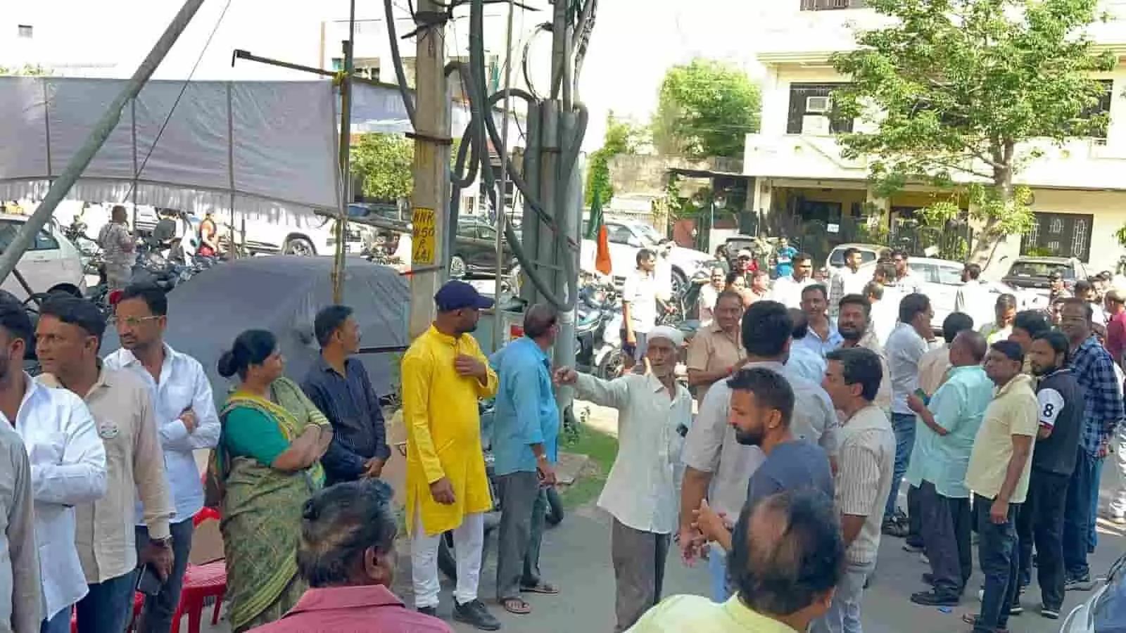 तस्वीर में कई लोग सड़क किनारे एक साथ खड़े होकर आपसी चर्चा करते दिख रहे हैं। तस्वीर में कई लोग सड़क किनारे एक साथ खड़े होकर आपसी चर्चा करते दिख रहे हैं।