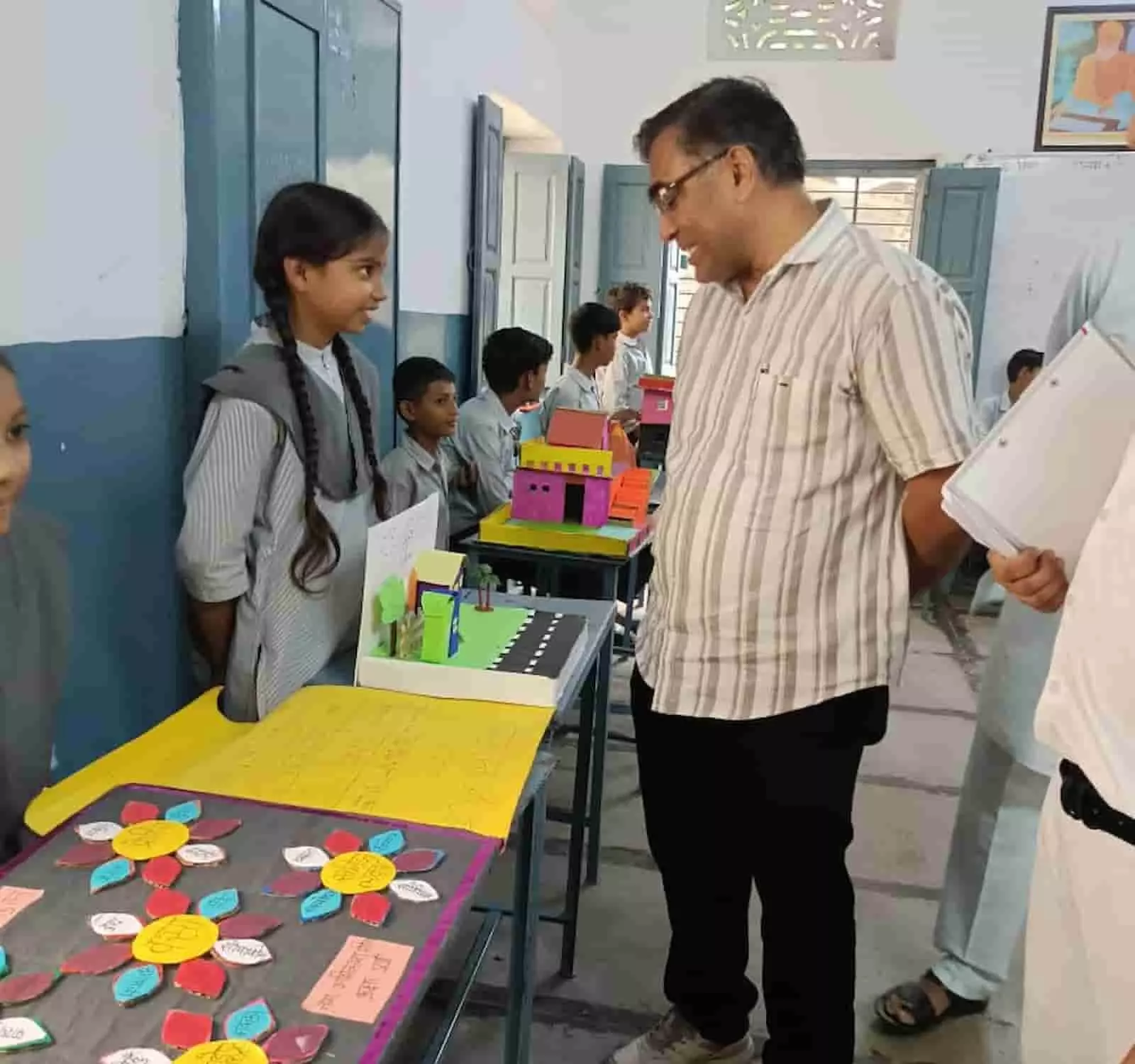 कक्षा में एक छात्रा टेबल पर रखे विज्ञान मॉडल के पास खड़े शिक्षक से बातचीत कर रही है। कक्षा में एक छात्रा टेबल पर रखे विज्ञान मॉडल के पास खड़े शिक्षक से बातचीत कर रही है।