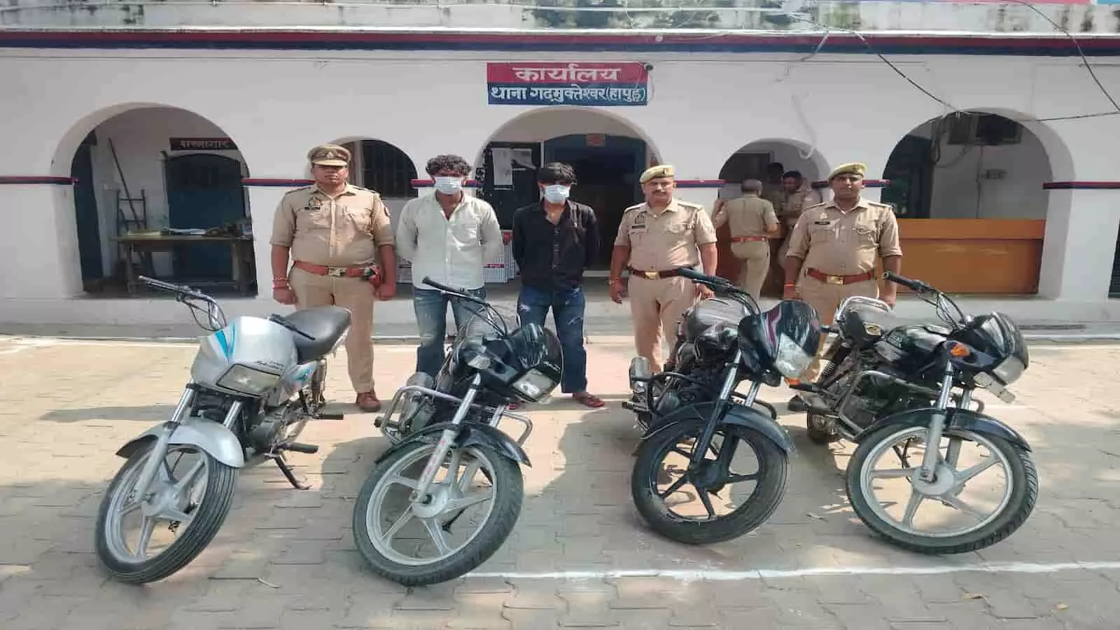 तस्वीर में गढ़मुक्तेश्वर पुलिस स्टेशन के बाहर पुलिसकर्मियों के साथ दो गिरफ्तार आरोपी और बरामद चार मोटरसाइकिलें दिख रही हैं। तस्वीर में गढ़मुक्तेश्वर पुलिस स्टेशन के बाहर पुलिसकर्मियों के साथ दो गिरफ्तार आरोपी और बरामद चार मोटरसाइकिलें दिख रही हैं।