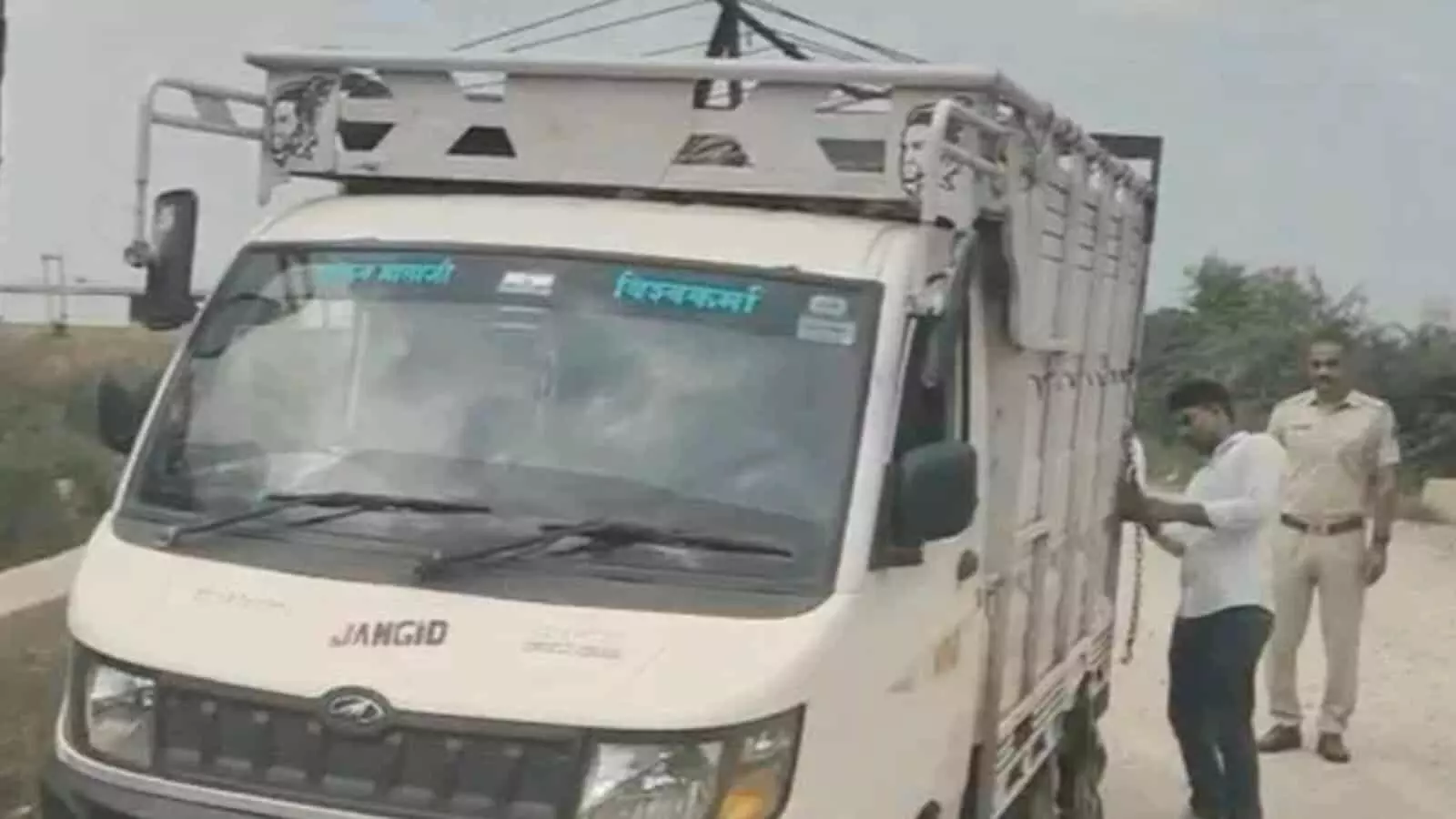 तस्वीर में सड़क किनारे खड़े सफेद लोडिंग टैंपो के पास एक व्यक्ति और पुलिसकर्मी खड़े दिखाई दे रहे हैं। तस्वीर में सड़क किनारे खड़े सफेद लोडिंग टैंपो के पास एक व्यक्ति और पुलिसकर्मी खड़े दिखाई दे रहे हैं।