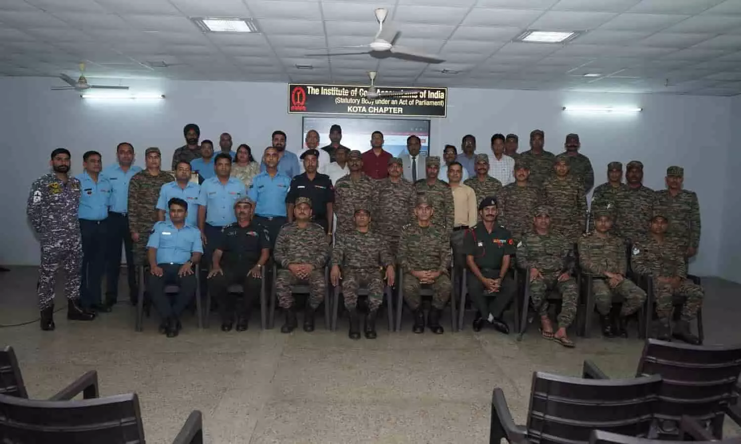 तस्वीर में हॉल के भीतर सैन्य वेशभूषा में बैठे और खड़े हुए सैनिकों तथा अधिकारियों का एक बड़ा समूह दिखाई दे रहा है. तस्वीर में हॉल के भीतर सैन्य वेशभूषा में बैठे और खड़े हुए सैनिकों तथा अधिकारियों का एक बड़ा समूह दिखाई दे रहा है.