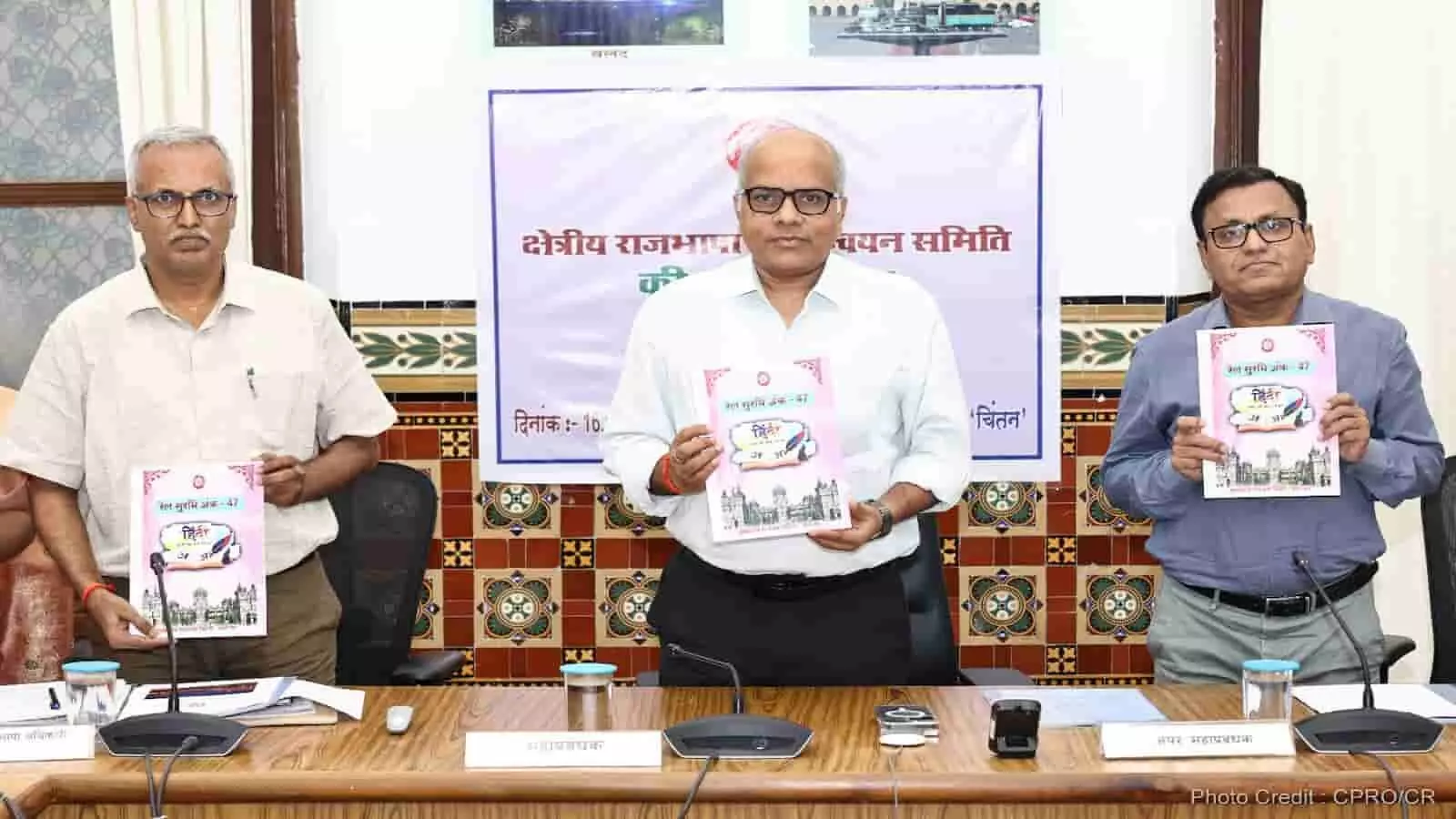 तस्वीर में दिख रही मेज के पीछे खड़े तीन अधिकारी हाथ में पत्रिका थामे नजर आ रहे हैं। तस्वीर में दिख रही मेज के पीछे खड़े तीन अधिकारी हाथ में पत्रिका थामे नजर आ रहे हैं।