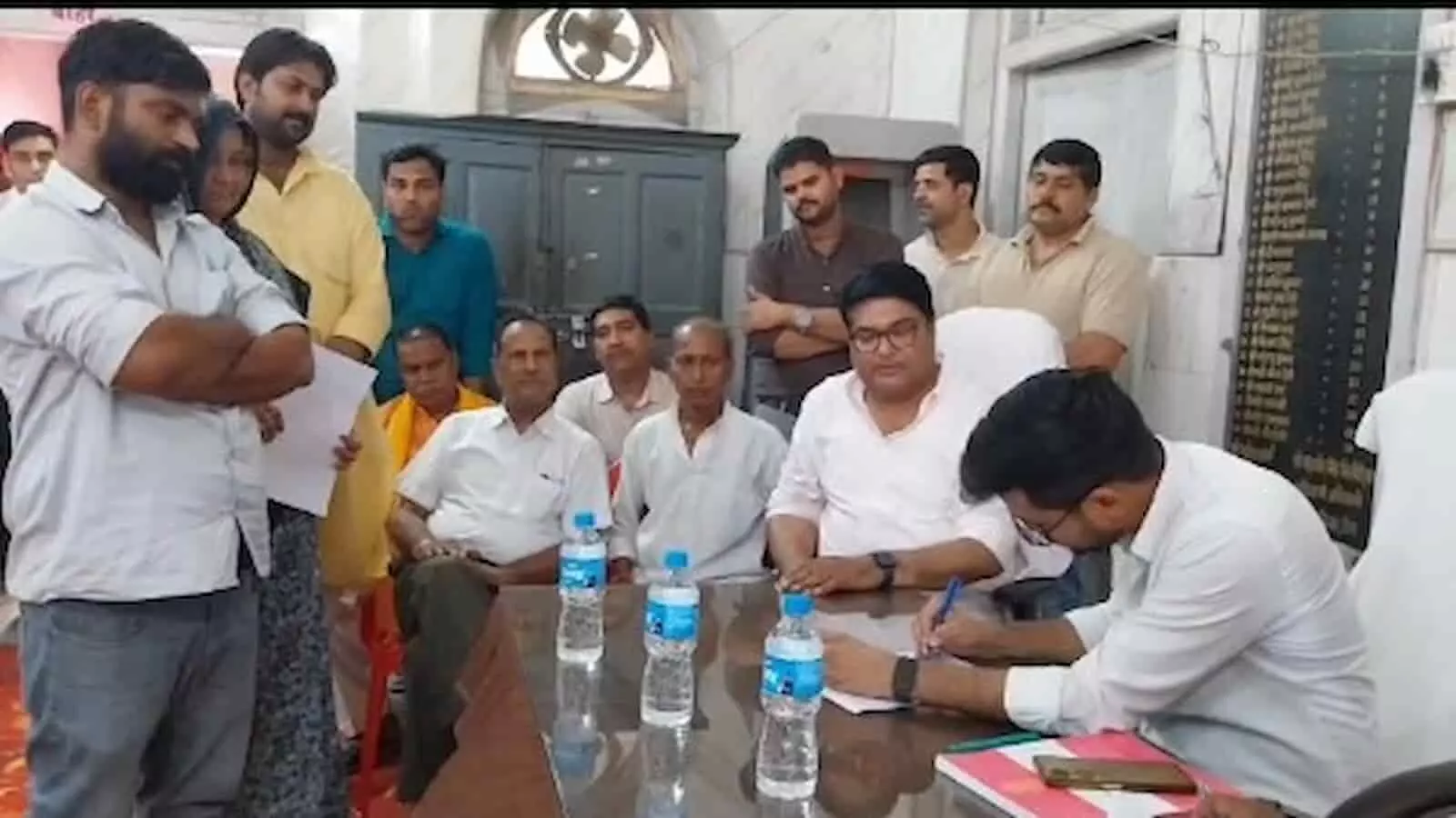 तस्वीर में डीग नगर परिषद कार्यालय के भीतर टेबल पर बैठे अधिकारी और आसपास खड़े लोग दिख रहे हैं। तस्वीर में डीग नगर परिषद कार्यालय के भीतर टेबल पर बैठे अधिकारी और आसपास खड़े लोग दिख रहे हैं।