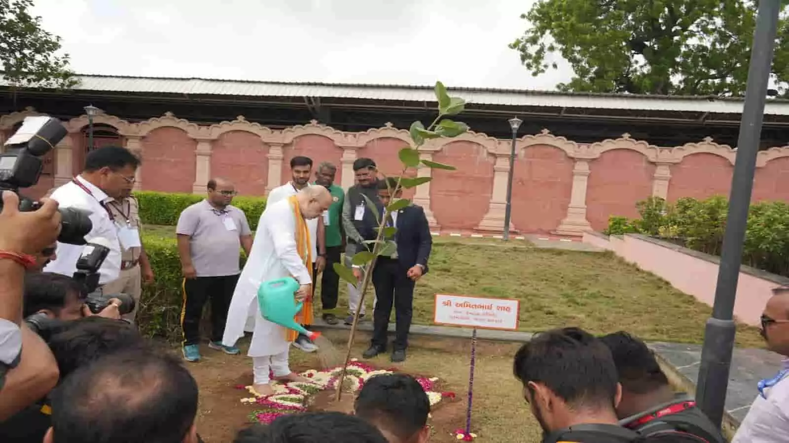 सफेद कुर्त-पायजामे में अमित शाह पौधे को पानी डालते हुए अन्य अधिकारियों के साथ नजर आ रहे हैं। सफेद कुर्त-पायजामे में अमित शाह पौधे को पानी डालते हुए अन्य अधिकारियों के साथ नजर आ रहे हैं।