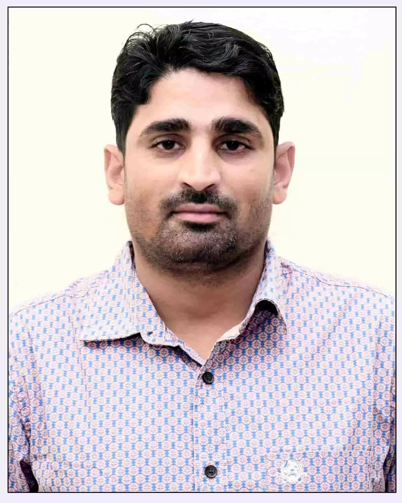 तस्वीर में एक व्यक्ति हल्के नीले और गुलाबी पैटर्न वाली शर्ट पहने हुए सीधे देखकर खड़ा है। तस्वीर में एक व्यक्ति हल्के नीले और गुलाबी पैटर्न वाली शर्ट पहने हुए सीधे देखकर खड़ा है।