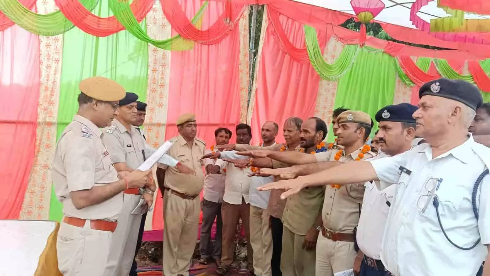 तस्वीर में बाईं ओर खड़े अधिकारी दस्तावेज पढ़ते दिख रहे हैं और बाकी पुलिसकर्मी शपथ ले रहे हैं। तस्वीर में बाईं ओर खड़े अधिकारी दस्तावेज पढ़ते दिख रहे हैं और बाकी पुलिसकर्मी शपथ ले रहे हैं।