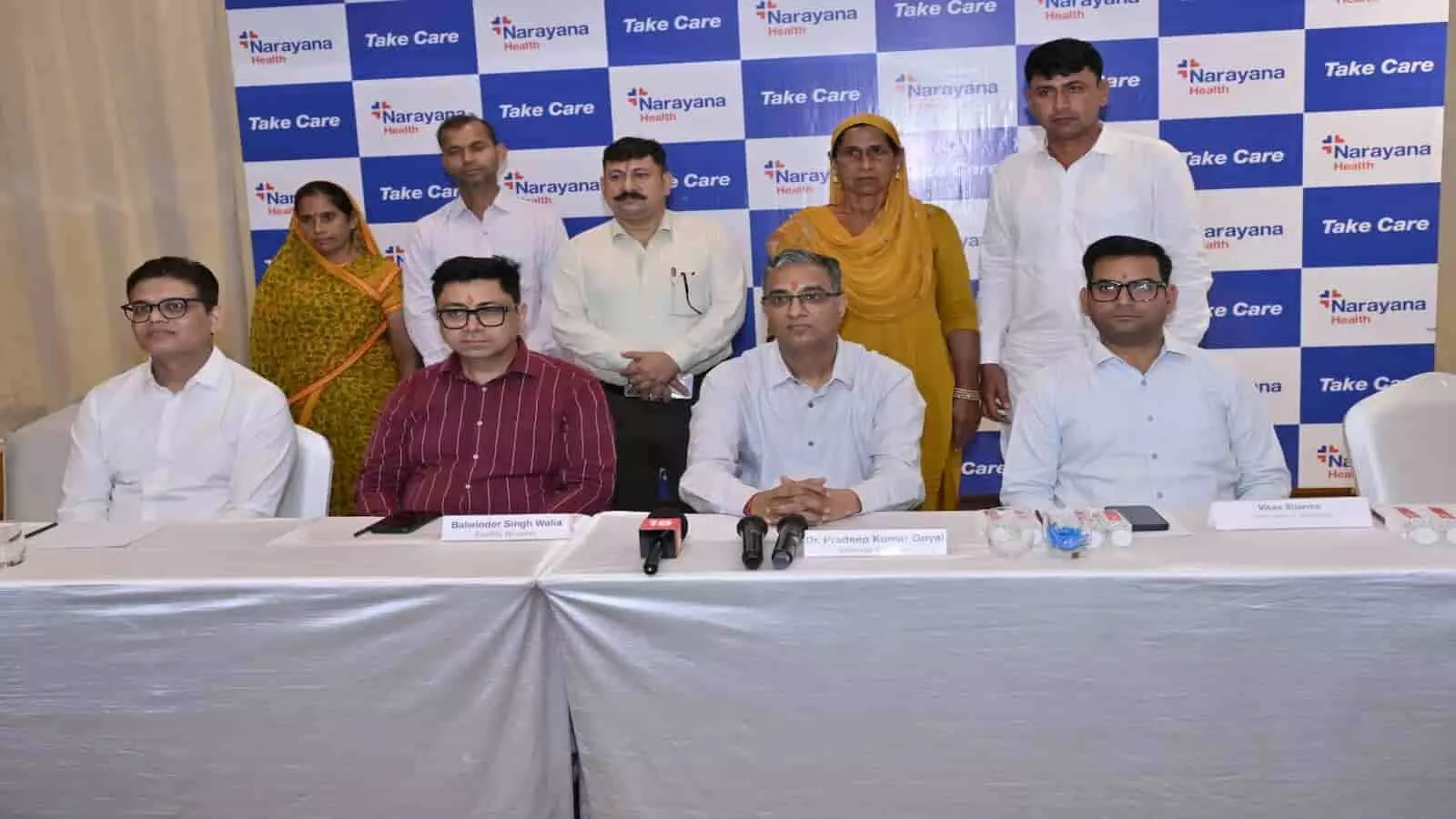 तस्वीर में नारायणा हॉस्पिटल के डॉक्टर्स, अधिकारी और मरीज एक प्रेस कॉन्फ्रेंस के दौरान मंच पर साथ बैठे और खड़े दिखाई दे रहे हैं। तस्वीर में नारायणा हॉस्पिटल के डॉक्टर्स, अधिकारी और मरीज एक प्रेस कॉन्फ्रेंस के दौरान मंच पर साथ बैठे और खड़े दिखाई दे रहे हैं।