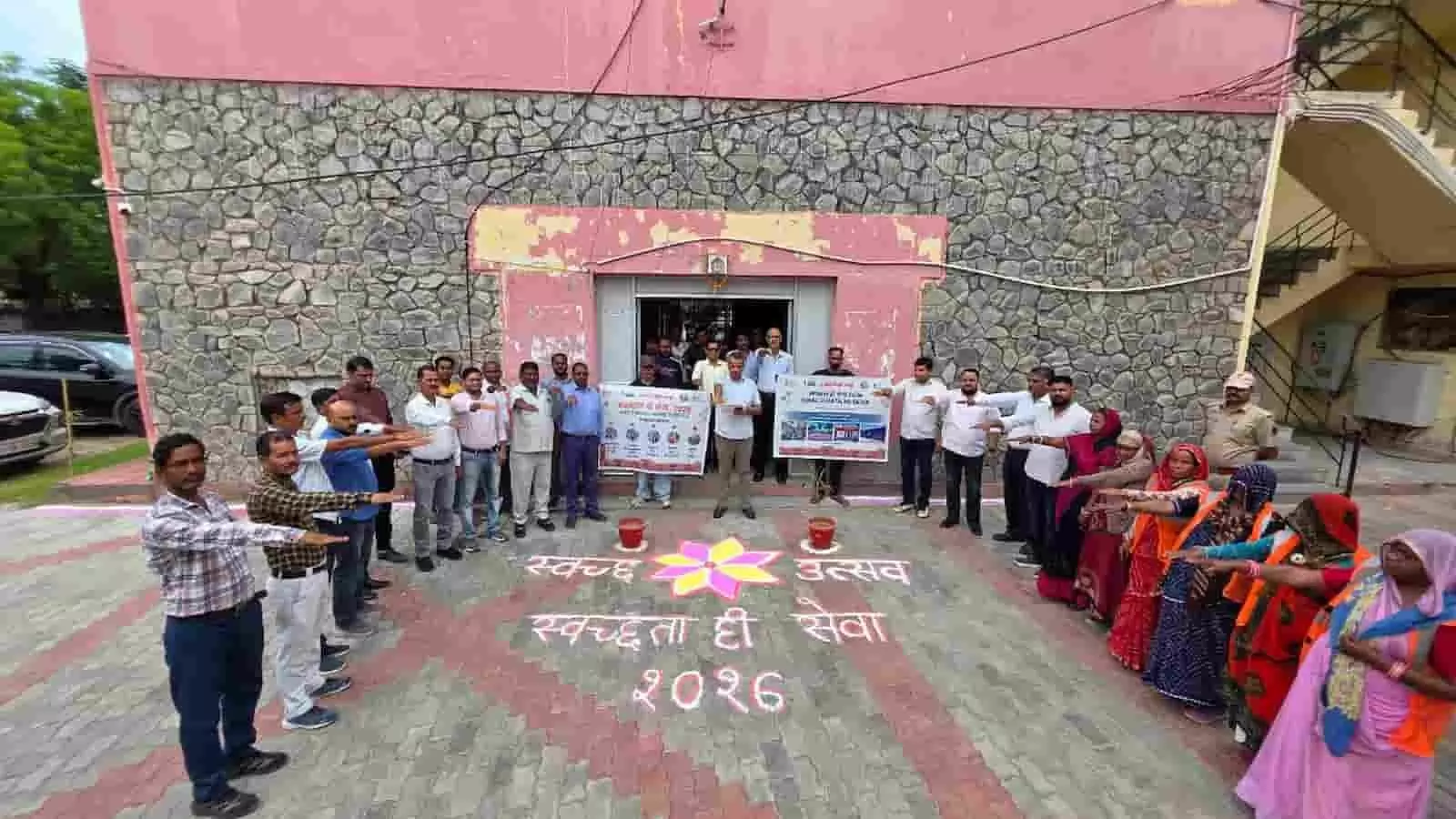 तस्वीर में दिख रही इमारत के सामने लोग एक कतार में खड़े होकर हाथ बढ़ाकर स्वच्छता की शपथ ले रहे हैं। तस्वीर में दिख रही इमारत के सामने लोग एक कतार में खड़े होकर हाथ बढ़ाकर स्वच्छता की शपथ ले रहे हैं।