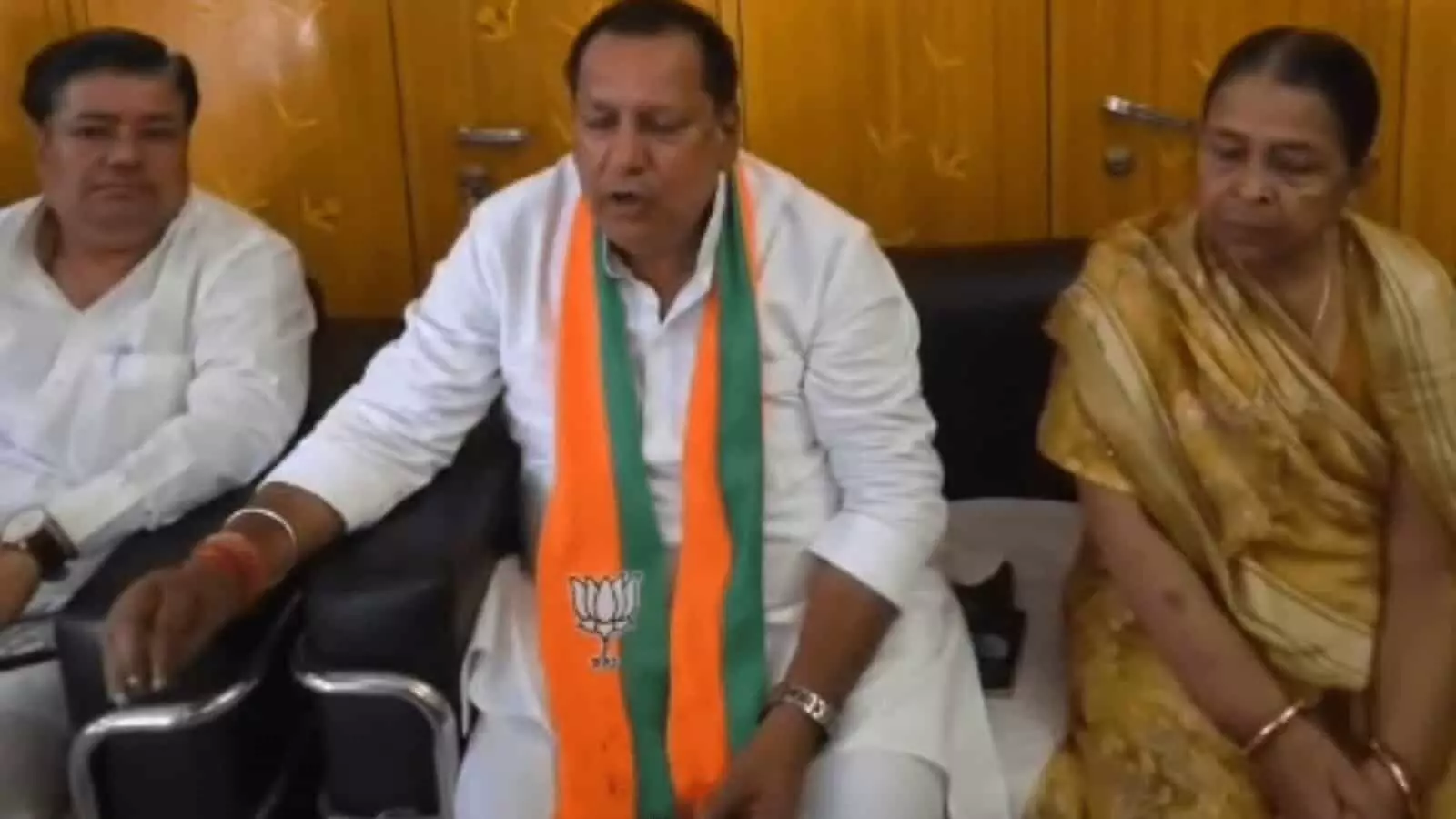तस्वीर में बाएं से दाएं बैठे हुए एक व्यक्ति, बीच में गले में भाजपा का पटका पहने मानसिंह गुर्जर और दाईं ओर बैठी महिला नजर आ रही हैं। तस्वीर में बाएं से दाएं बैठे हुए एक व्यक्ति, बीच में गले में भाजपा का पटका पहने मानसिंह गुर्जर और दाईं ओर बैठी महिला नजर आ रही हैं।