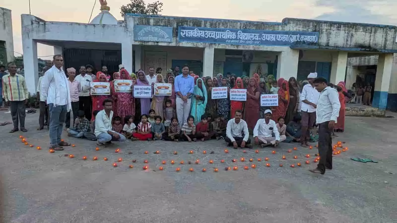 तस्वीर में उपला फला स्कूल परिसर में खाद्य सुरक्षा योजना के लाभार्थी दीये जलाकर खड़े हैं। तस्वीर में उपला फला स्कूल परिसर में खाद्य सुरक्षा योजना के लाभार्थी दीये जलाकर खड़े हैं।