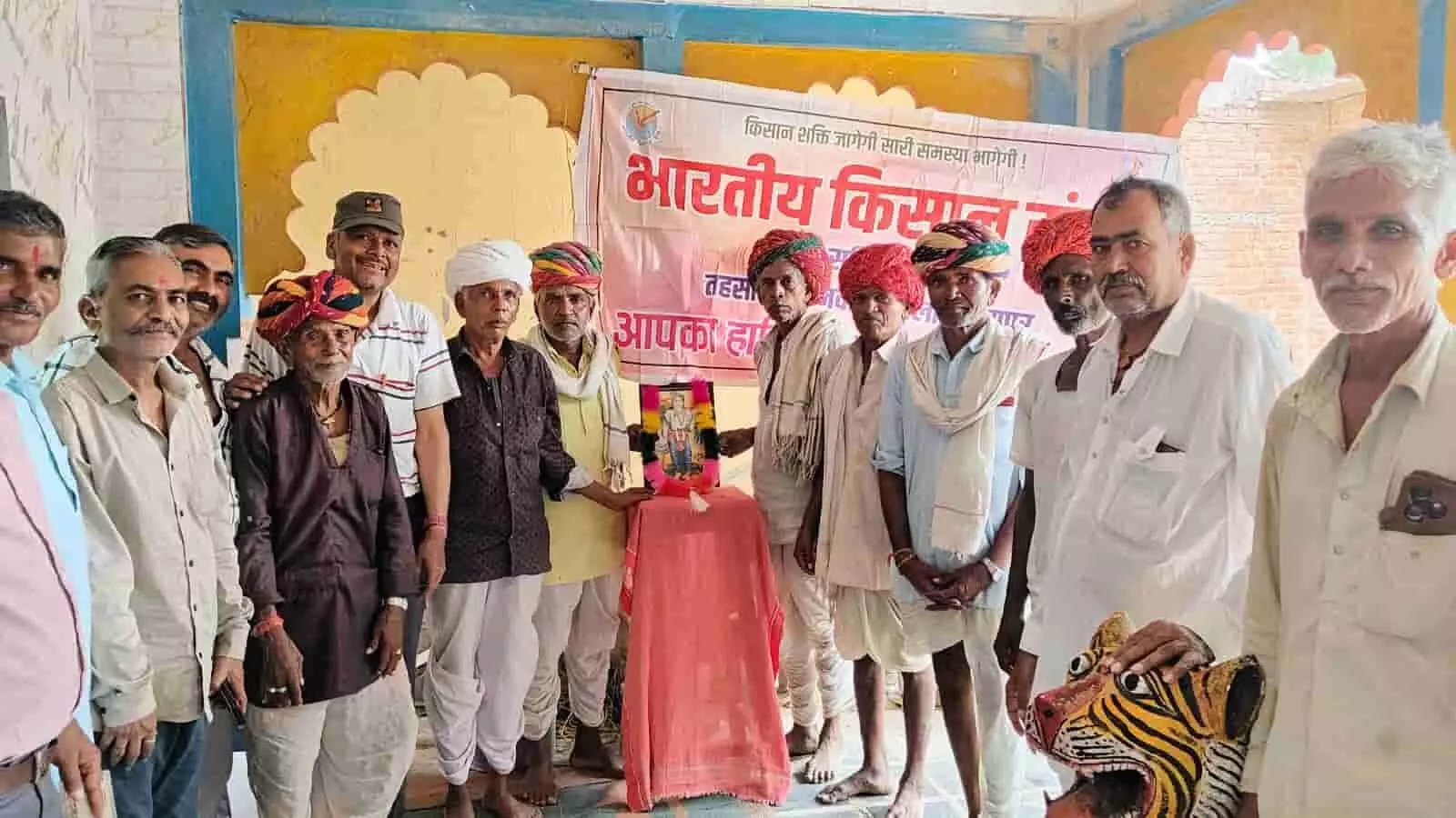 तस्वीर में नाहर सिंह माता मंदिर परिसर में भगवान बलराम के चित्र के समक्ष खड़े साफे पहने ग्रामीण और किसान दिखाई दे रहे हैं। तस्वीर में नाहर सिंह माता मंदिर परिसर में भगवान बलराम के चित्र के समक्ष खड़े साफे पहने ग्रामीण और किसान दिखाई दे रहे हैं।