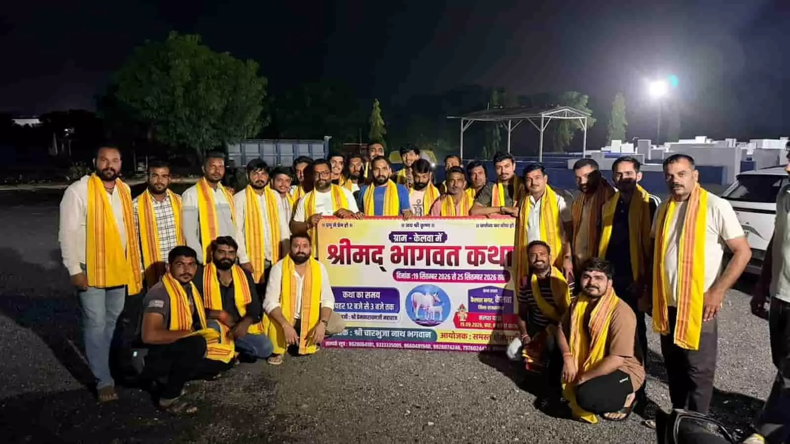 तस्वीर में रात के समय खुले मैदान में श्रीमद् भागवत कथा के बैनर के पास खड़े स्थानीय युवा दिखाई दे रहे हैं। तस्वीर में रात के समय खुले मैदान में श्रीमद् भागवत कथा के बैनर के पास खड़े स्थानीय युवा दिखाई दे रहे हैं।