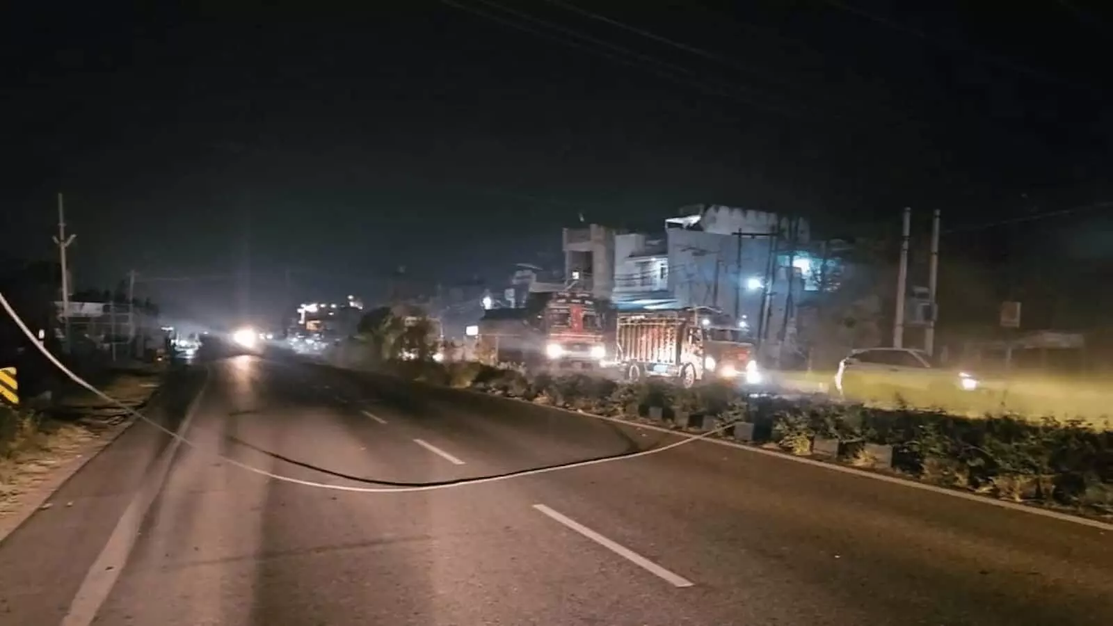 : तस्वीर में रात के समय हापुड़ के राष्ट्रीय राजमार्ग पर सड़क पर गिरे हाई टेंशन बिजली के तार और खड़े वाहन नजर आ रहे हैं。 : तस्वीर में रात के समय हापुड़ के राष्ट्रीय राजमार्ग पर सड़क पर गिरे हाई टेंशन बिजली के तार और खड़े वाहन नजर आ रहे हैं。