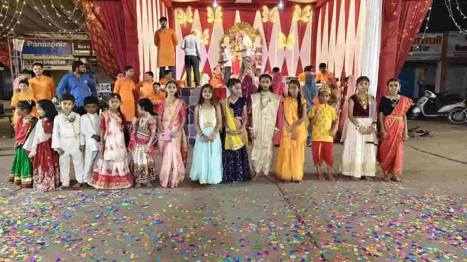 तस्वीर में पारंपरिक और धार्मिक वेशभूषा पहने बच्चे गणेश पांडाल के मंच के आगे खड़े दिखाई दे रहे हैं। तस्वीर में पारंपरिक और धार्मिक वेशभूषा पहने बच्चे गणेश पांडाल के मंच के आगे खड़े दिखाई दे रहे हैं।