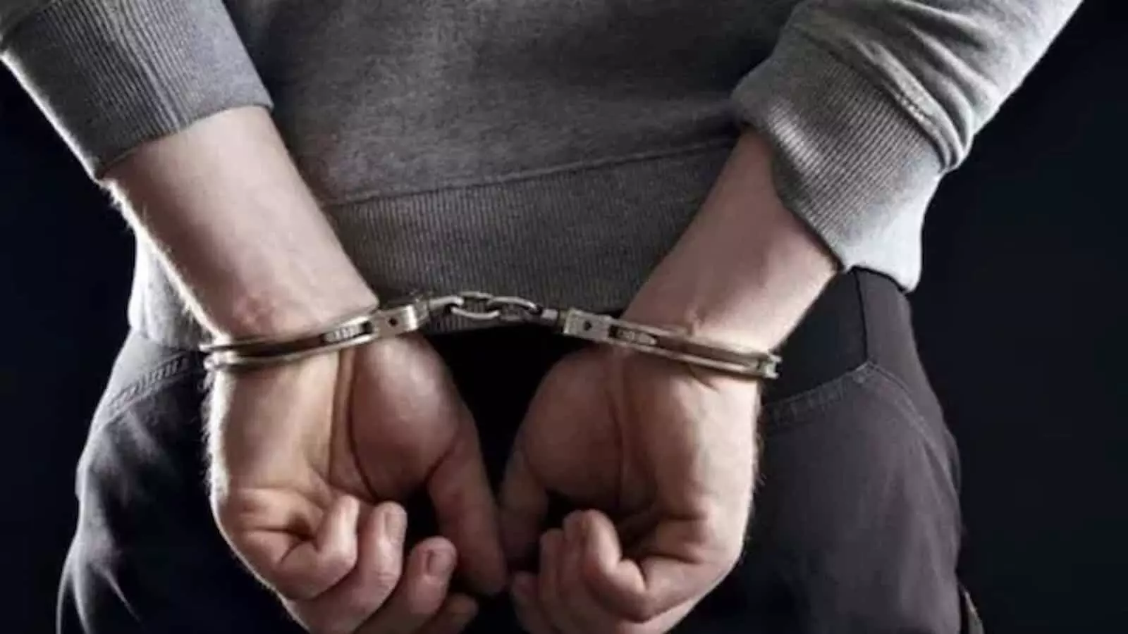 तस्वीर में दिख रही एक व्यक्ति की पीठ, जिसके हाथों में लोहे की हथकड़ी लगी है। तस्वीर में दिख रही एक व्यक्ति की पीठ, जिसके हाथों में लोहे की हथकड़ी लगी है।