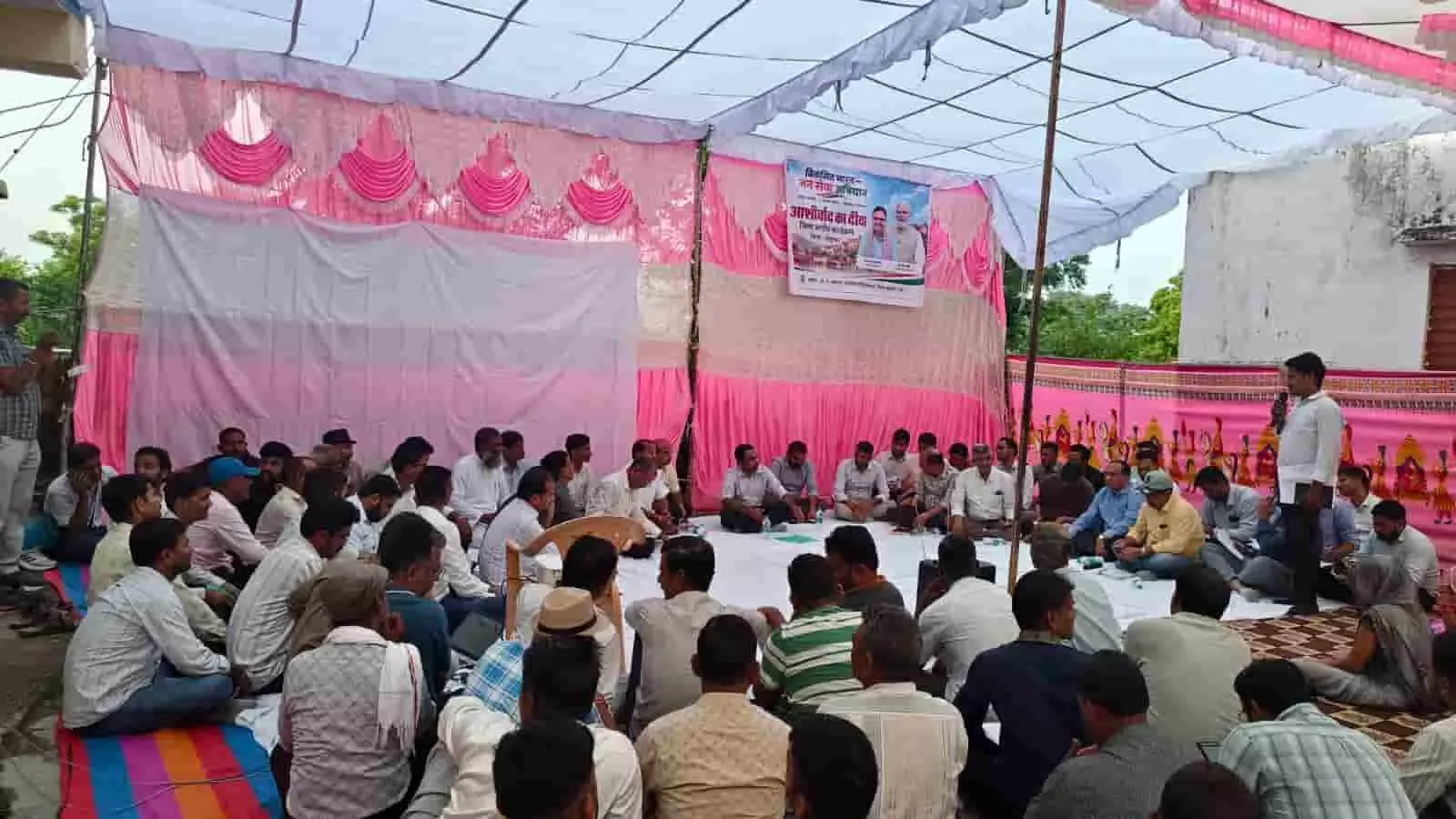 तस्वीर में दिख रही रात्रि चौपाल में पंडाल के नीचे बैठे अधिकारियों और ग्रामीणों को एक व्यक्ति संबोधित कर रहा है। तस्वीर में दिख रही रात्रि चौपाल में पंडाल के नीचे बैठे अधिकारियों और ग्रामीणों को एक व्यक्ति संबोधित कर रहा है।