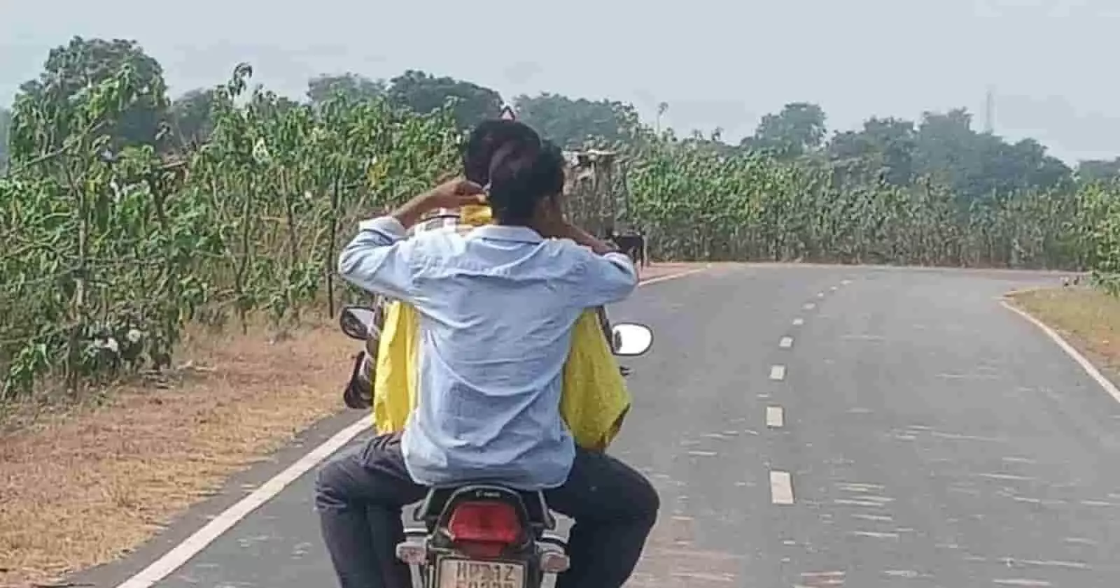 तस्वीर में मोटरसाइकिल पर पीछे से दिख रहे दो लोग सड़क पर सफर कर रहे हैं। तस्वीर में मोटरसाइकिल पर पीछे से दिख रहे दो लोग सड़क पर सफर कर रहे हैं।