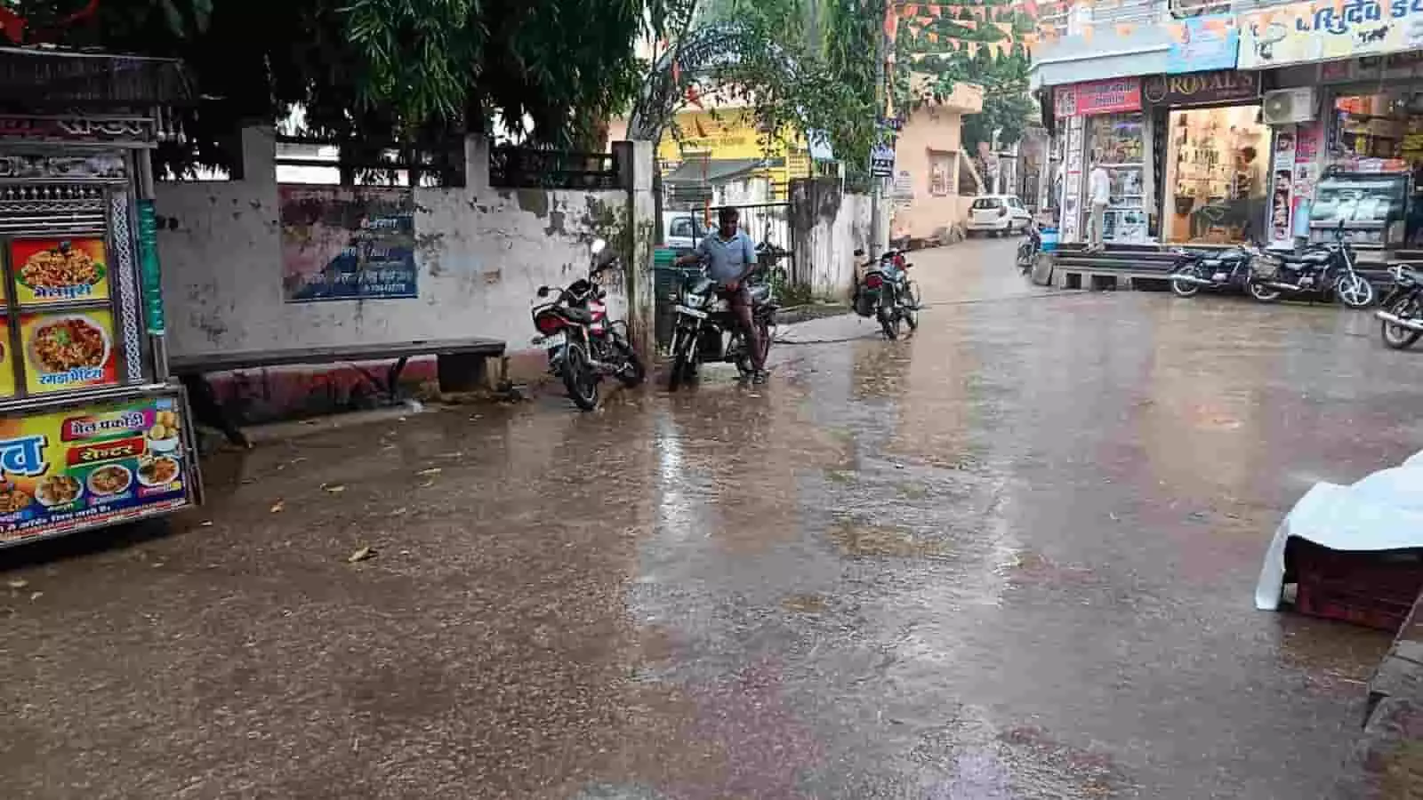 खेरोदा कस्बे में बारिश के बाद गीली सड़क और खड़े वाहन खेरोदा कस्बे में बारिश के बाद गीली सड़क और खड़े वाहन