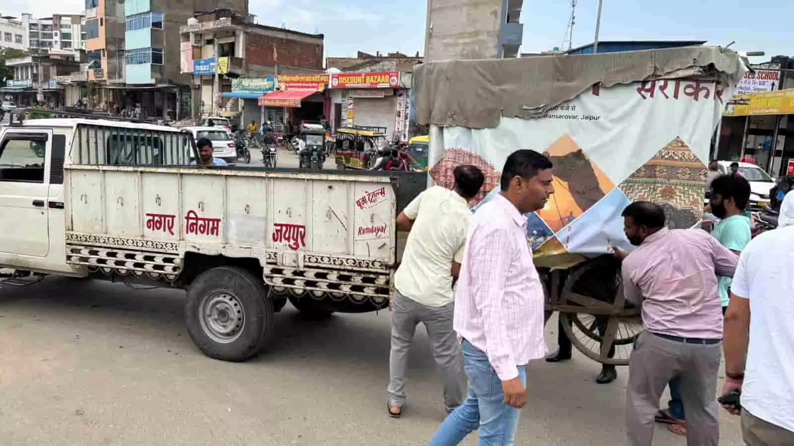 तस्वीर में दिख रही सड़क पर जयपुर नगर निगम के कर्मचारी अतिक्रमण का सामान ट्रक में लाद रहे हैं। तस्वीर में दिख रही सड़क पर जयपुर नगर निगम के कर्मचारी अतिक्रमण का सामान ट्रक में लाद रहे हैं।