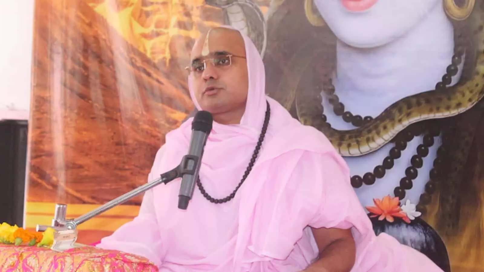 तस्वीर में गुलाबी वस्त्र पहने संत दिग्विजय राम माइक के सामने बैठकर प्रवचन देते हुए दिख रहे हैं। तस्वीर में गुलाबी वस्त्र पहने संत दिग्विजय राम माइक के सामने बैठकर प्रवचन देते हुए दिख रहे हैं।