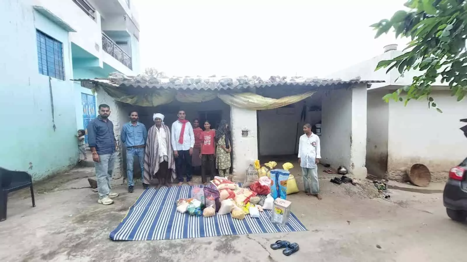 तस्वीर में एक घर के बाहर कुछ लोग और पीड़ित परिवार के सदस्य राशन सामग्री के पास खड़े नजर आ रहे हैं। तस्वीर में एक घर के बाहर कुछ लोग और पीड़ित परिवार के सदस्य राशन सामग्री के पास खड़े नजर आ रहे हैं।