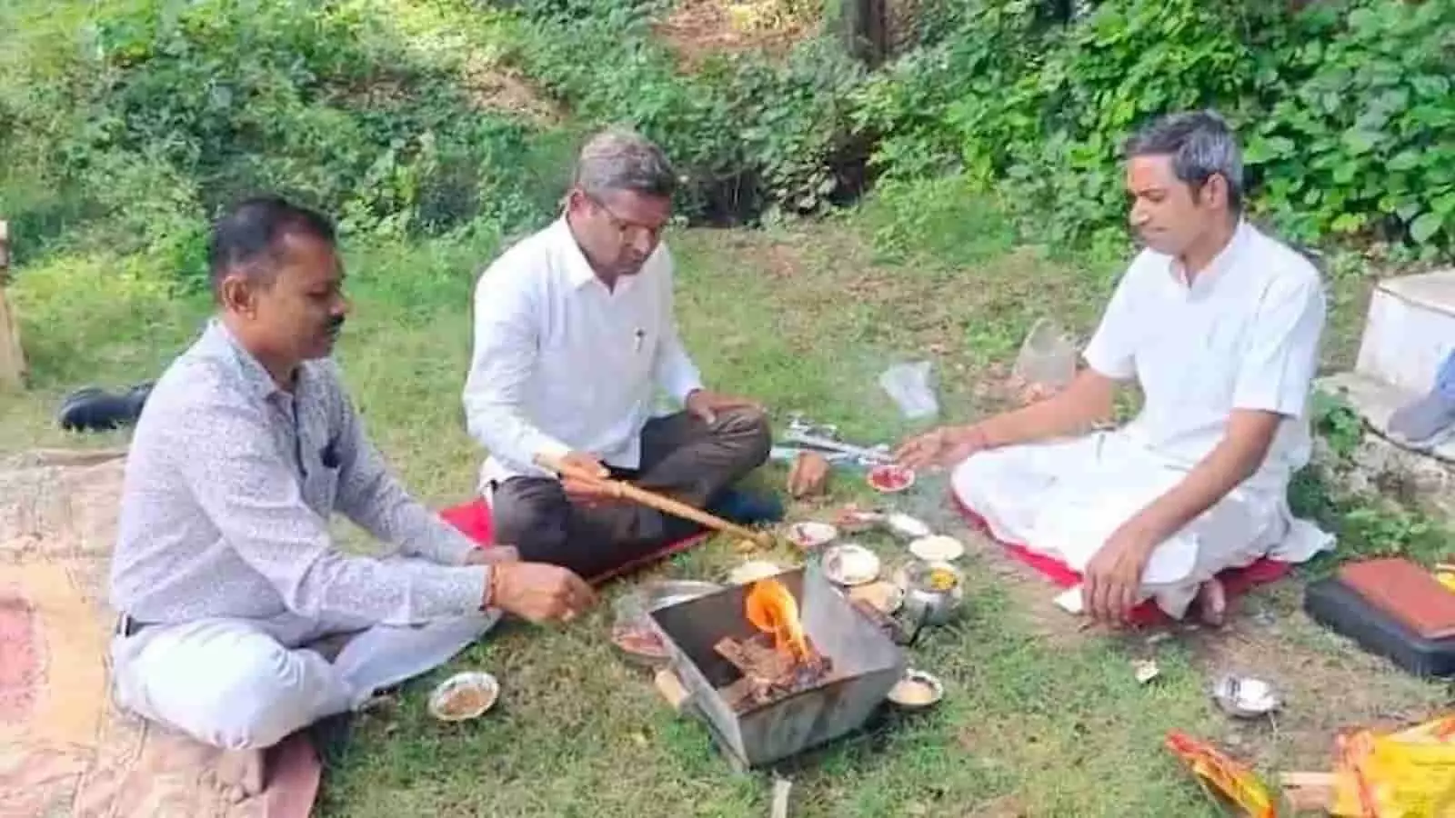 तस्वीर में तीन लोग जमीन पर बैठकर यज्ञ कुंड में आहुति देते हुए नजर आ रहे हैं। तस्वीर में तीन लोग जमीन पर बैठकर यज्ञ कुंड में आहुति देते हुए नजर आ रहे हैं।