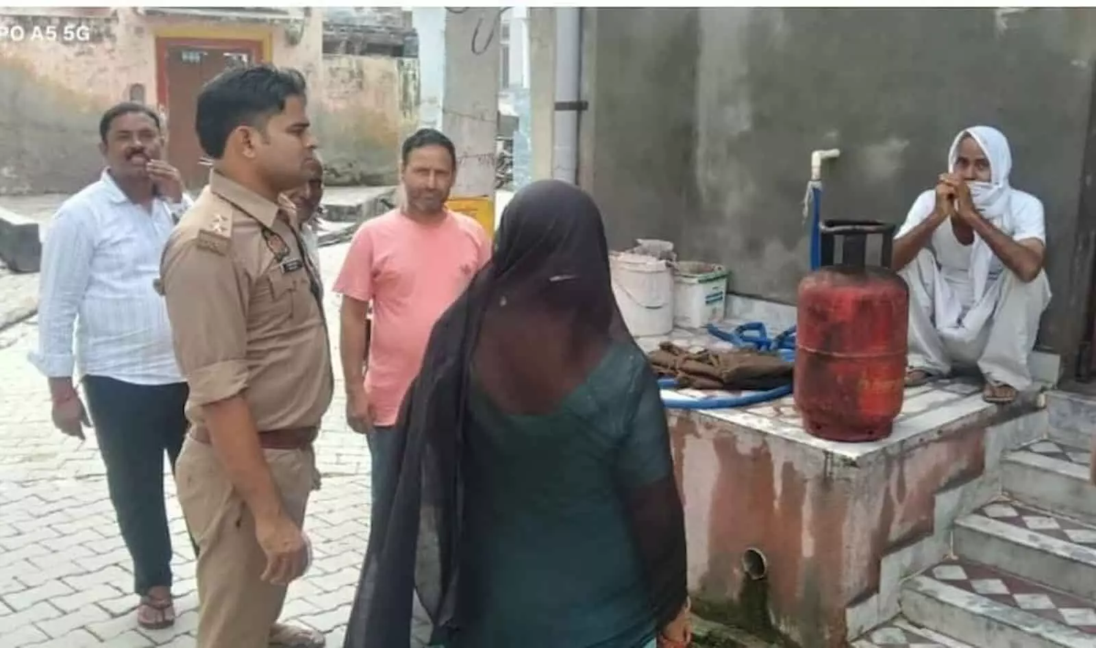 तस्वीर में बाएं से दाएं खड़े पुलिसकर्मी और ग्रामीण मकान के बाहर रखे लाल एलपीजी सिलेंडर की जांच कर रहे हैं। तस्वीर में बाएं से दाएं खड़े पुलिसकर्मी और ग्रामीण मकान के बाहर रखे लाल एलपीजी सिलेंडर की जांच कर रहे हैं।