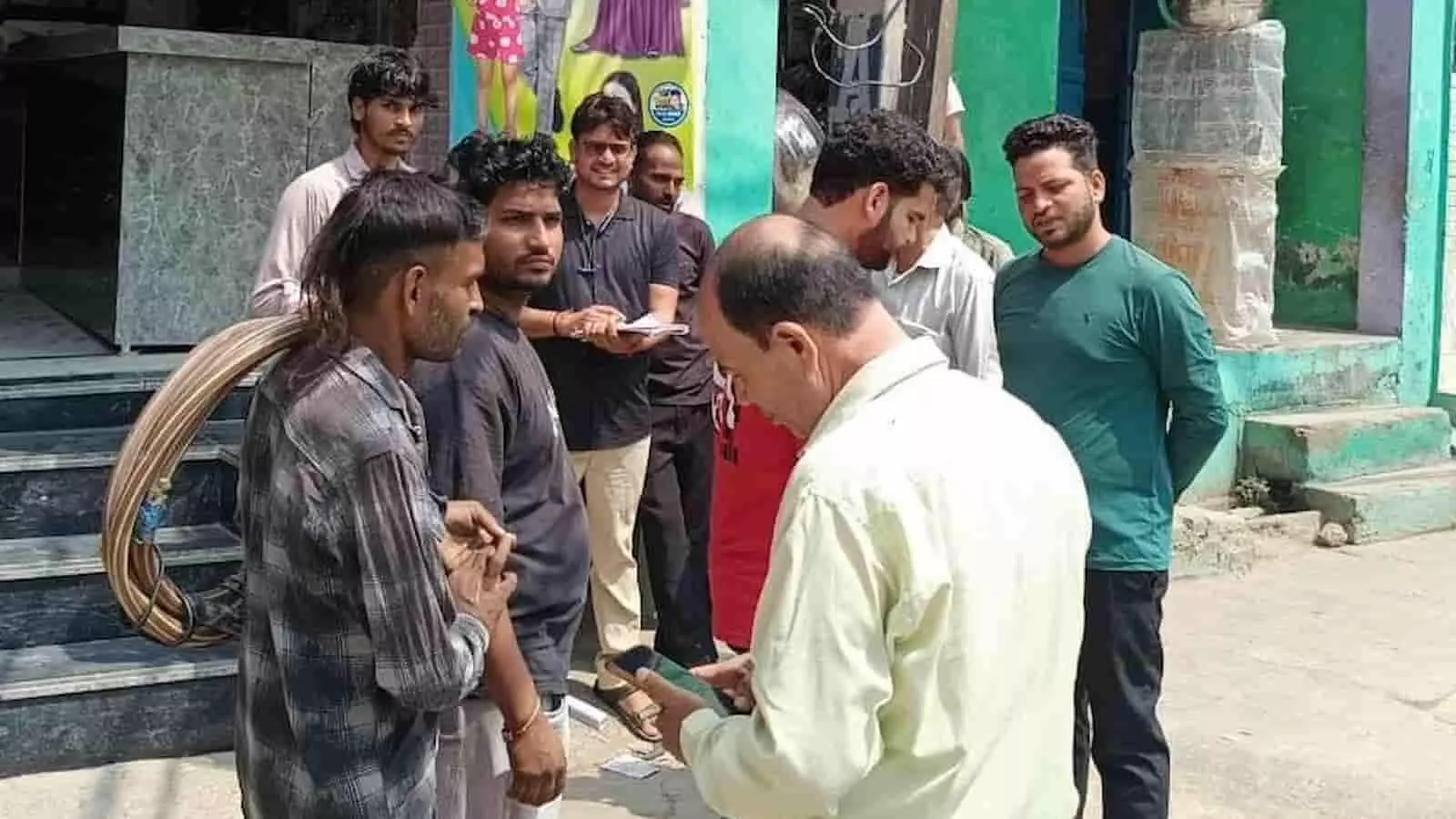 तस्वीर में दिख रही बिजली विभाग की टीम कंधे पर केबल तार लिए खड़े व्यक्ति से बातचीत कर रही है। तस्वीर में दिख रही बिजली विभाग की टीम कंधे पर केबल तार लिए खड़े व्यक्ति से बातचीत कर रही है।