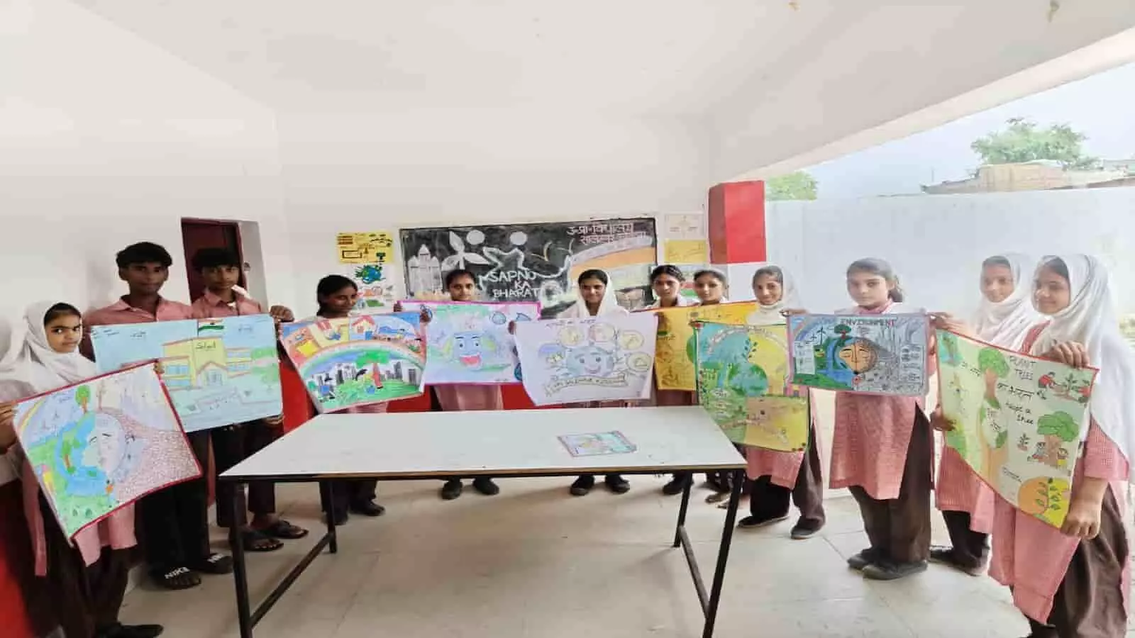 तस्वीर में दिख रहे स्कूली छात्र-छात्राएं एक मेज के पीछे खड़े होकर पोस्टर प्रदर्शित कर रहे हैं। तस्वीर में दिख रहे स्कूली छात्र-छात्राएं एक मेज के पीछे खड़े होकर पोस्टर प्रदर्शित कर रहे हैं।