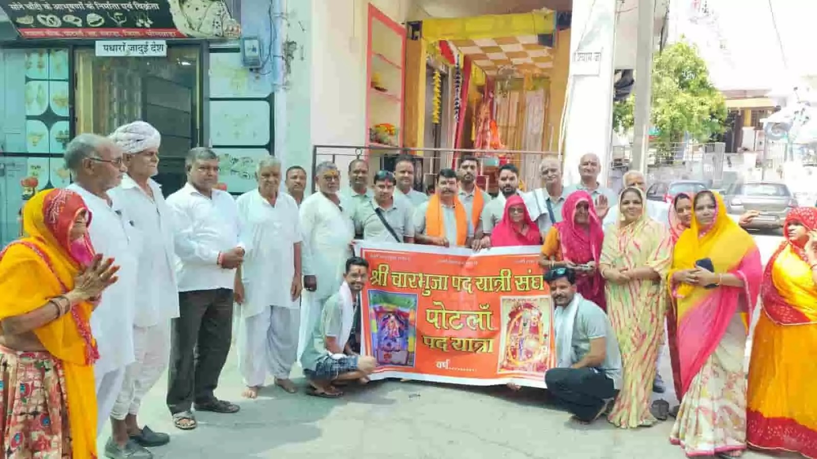 तस्वीर में पोटलां कस्बे के मंदिर के बाहर चारभुजा पदयात्रा का बैनर पकड़े ग्रामीण और पदयात्री खड़े हैं। तस्वीर में पोटलां कस्बे के मंदिर के बाहर चारभुजा पदयात्रा का बैनर पकड़े ग्रामीण और पदयात्री खड़े हैं।