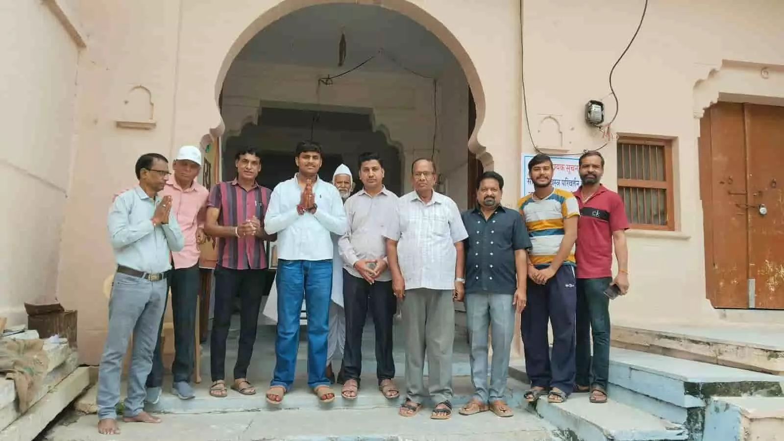 तस्वीर में दिख रही इमारत के सामने कई लोग एक साथ खड़े होकर अभिवादन कर रहे हैं। तस्वीर में दिख रही इमारत के सामने कई लोग एक साथ खड़े होकर अभिवादन कर रहे हैं।