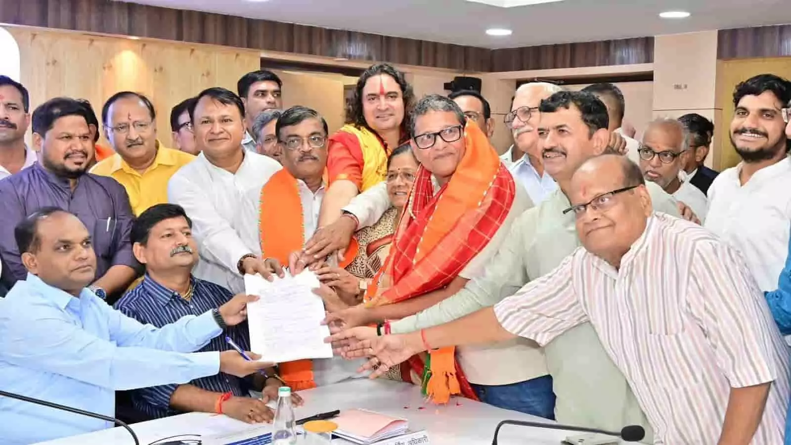 तस्वीर में दिख रही कमरे की मेज पर बैठे अधिकारियों को सुनील कोठारी और अन्य नेता दस्तावेज दे रहे हैं। तस्वीर में दिख रही कमरे की मेज पर बैठे अधिकारियों को सुनील कोठारी और अन्य नेता दस्तावेज दे रहे हैं।