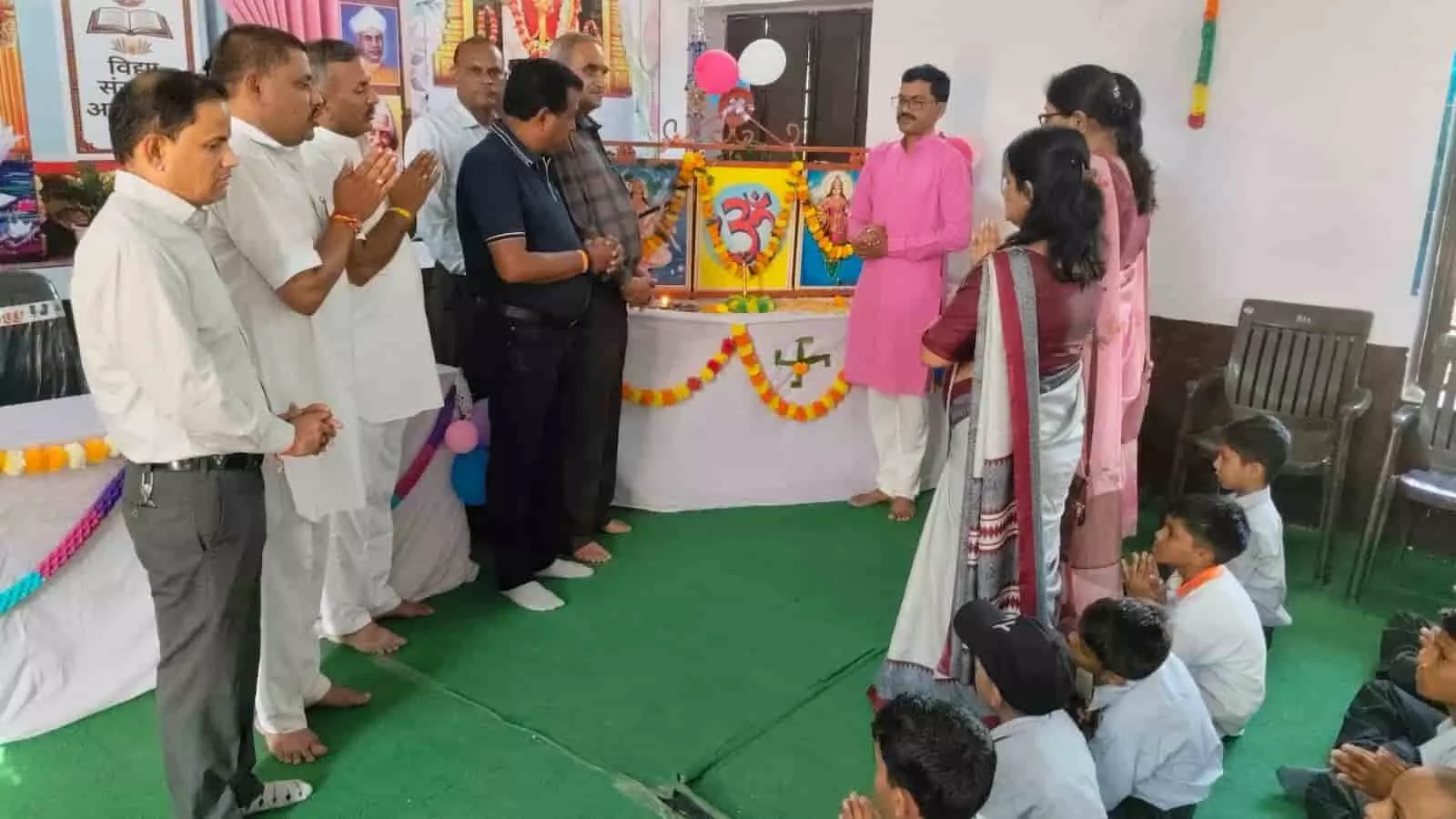 तस्वीर में अतिथि और शिक्षक कार्यक्रम के दौरान हाथ जोड़कर खड़े हैं और सामने कुछ विद्यार्थी बैठे हैं। तस्वीर में अतिथि और शिक्षक कार्यक्रम के दौरान हाथ जोड़कर खड़े हैं और सामने कुछ विद्यार्थी बैठे हैं।