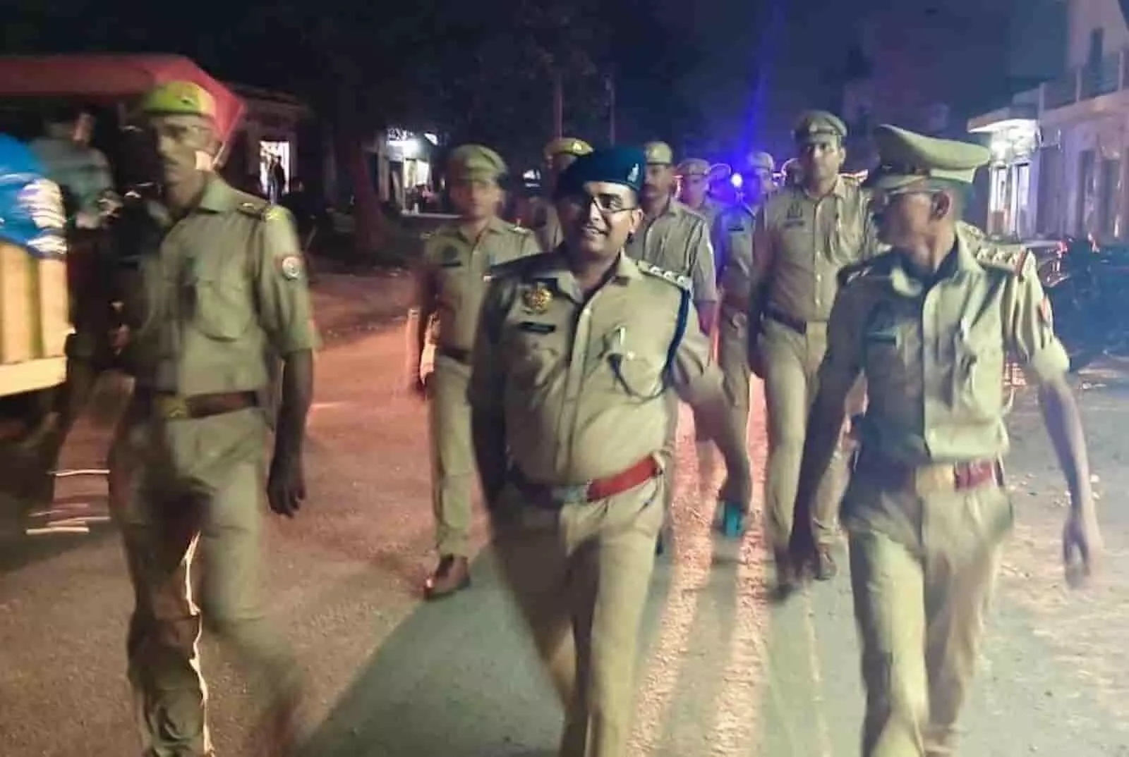 तस्वीर में रात के समय वर्दी पहने पुलिसकर्मी सड़क पर पैदल मार्च करते हुए दिखाई दे रहे हैं। तस्वीर में रात के समय वर्दी पहने पुलिसकर्मी सड़क पर पैदल मार्च करते हुए दिखाई दे रहे हैं।