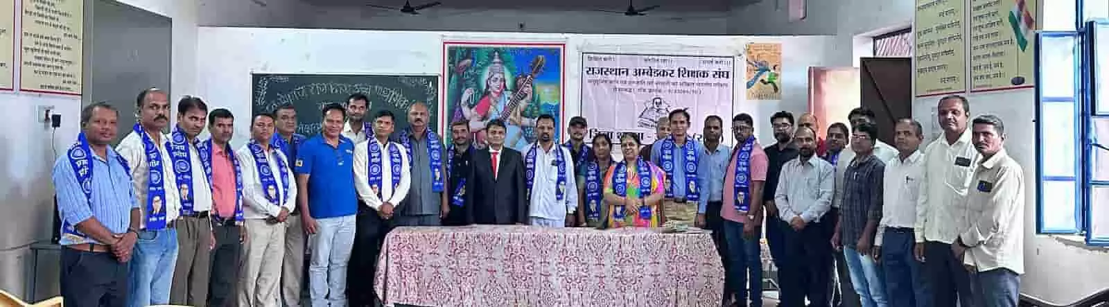 तस्वीर में उदयपुर के स्कूल हॉल में राजस्थान अंबेडकर शिक्षक संघ के सम्मेलन में खड़े शिक्षक और पदाधिकारी नजर आ रहे हैं। तस्वीर में उदयपुर के स्कूल हॉल में राजस्थान अंबेडकर शिक्षक संघ के सम्मेलन में खड़े शिक्षक और पदाधिकारी नजर आ रहे हैं।