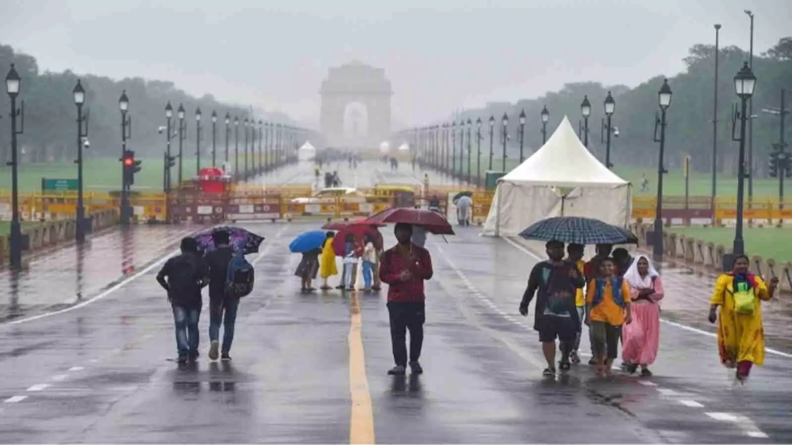 दिल्ली की बारिश के दौरान कर्तव्य पथ पर छाता लेकर चलते लोग। दिल्ली की बारिश के दौरान कर्तव्य पथ पर छाता लेकर चलते लोग।