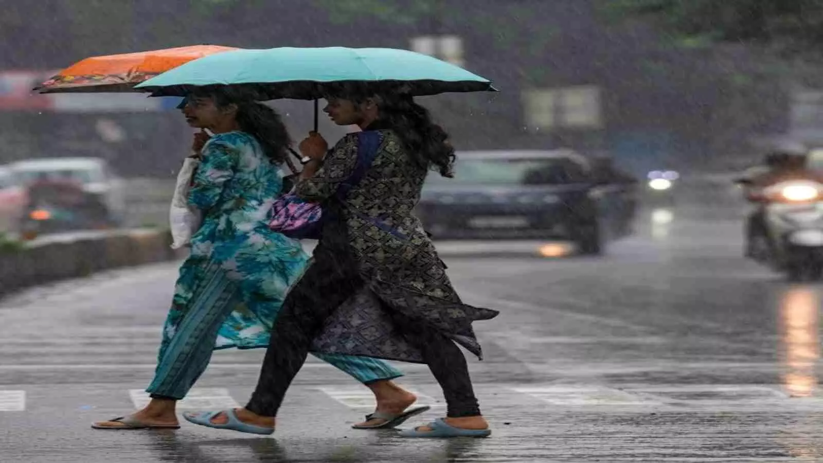 बारिश के दौरान सड़क पर छाता लेकर चलती दो महिलाएं दक्षिण भारत में मौसम की गतिविधि के संदर्भ में। बारिश के दौरान सड़क पर छाता लेकर चलती दो महिलाएं दक्षिण भारत में मौसम की गतिविधि के संदर्भ में।