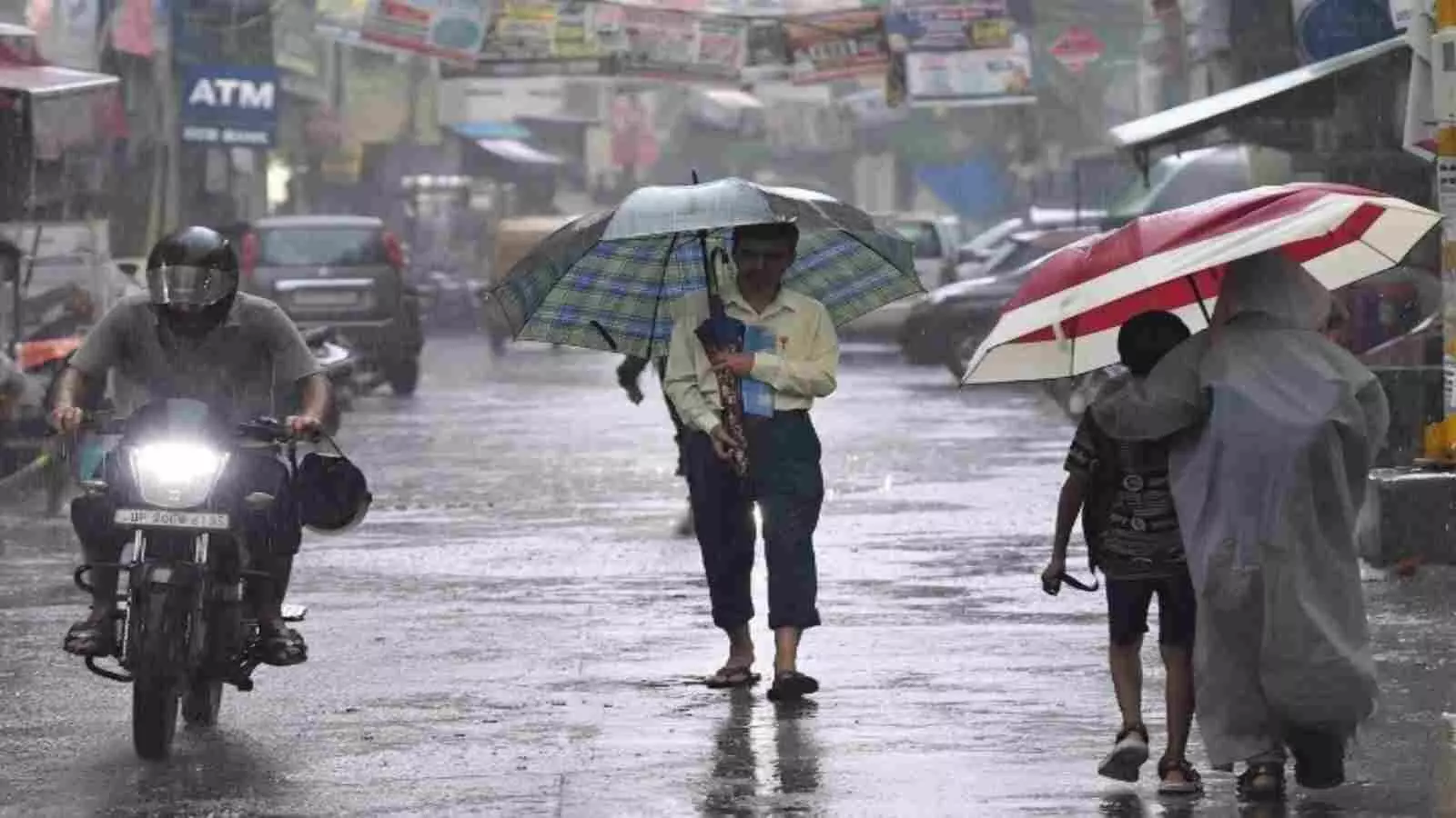बारिश के बीच उत्तर भारत की सड़क पर छाता लेकर चलते लोग मौसम की गतिविधि के संदर्भ में। बारिश के बीच उत्तर भारत की सड़क पर छाता लेकर चलते लोग मौसम की गतिविधि के संदर्भ में।