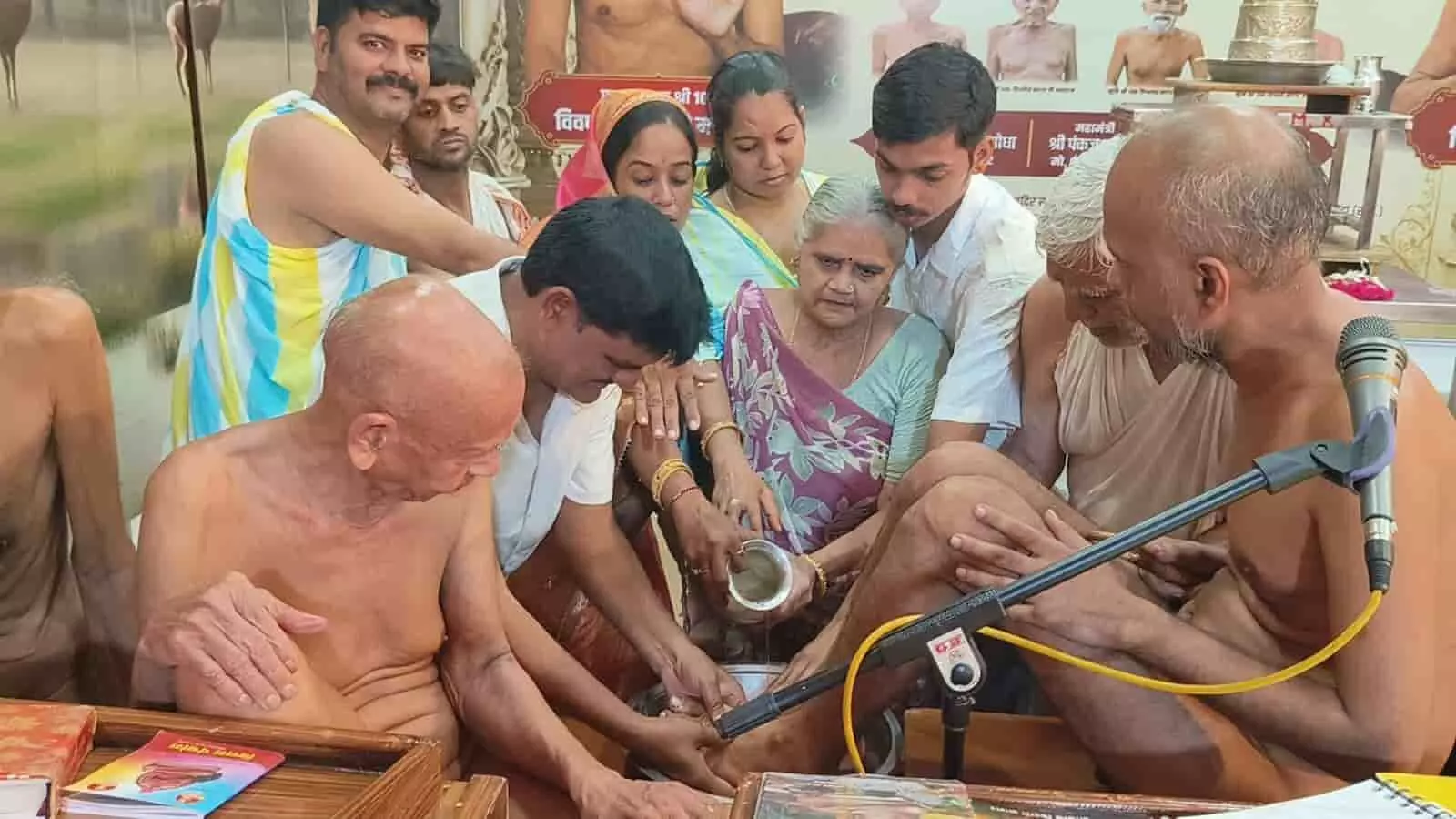 तस्वीर में बाएं से दाएं बैठे हुए मुनिराज और उनके पास खड़े श्रद्धालु जल से चरण धोते हुए दिखाई दे रहे हैं। तस्वीर में बाएं से दाएं बैठे हुए मुनिराज और उनके पास खड़े श्रद्धालु जल से चरण धोते हुए दिखाई दे रहे हैं।
