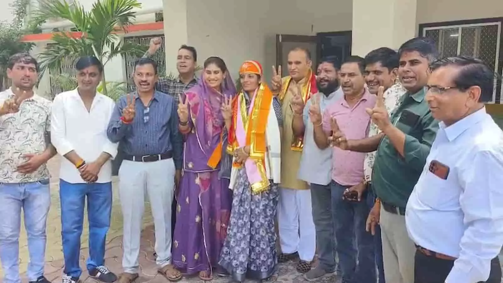 तस्वीर में बाएं से दाएं विभिन्न कपड़ों में खड़े कई लोग विक्ट्री का निशान बनाते हुए दिखाई दे रहे हैं। तस्वीर में बाएं से दाएं विभिन्न कपड़ों में खड़े कई लोग विक्ट्री का निशान बनाते हुए दिखाई दे रहे हैं।