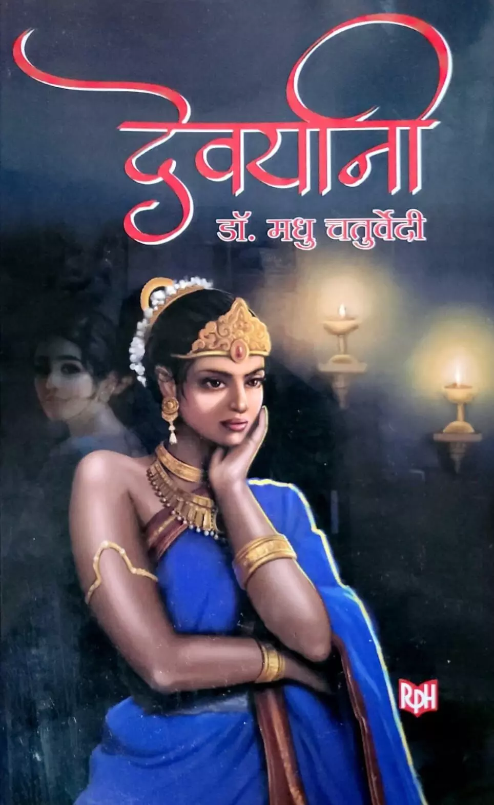 तस्वीर में ऊपर लाल रंग में पुस्तक का नाम और नीले वस्त्र पहने एक महिला का चित्र दिखाई दे रहा है। तस्वीर में ऊपर लाल रंग में पुस्तक का नाम और नीले वस्त्र पहने एक महिला का चित्र दिखाई दे रहा है।
