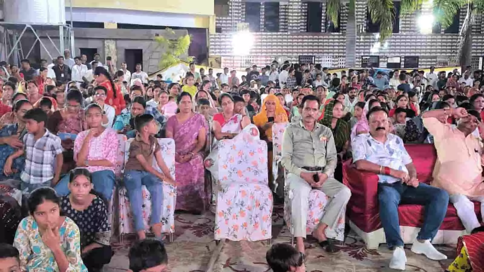 तस्वीर में आगे की सीटों पर बैठे हुए अतिथि और पीछे कुर्सियों पर बैठे हुए दर्शक दिखाई दे रहे हैं। तस्वीर में आगे की सीटों पर बैठे हुए अतिथि और पीछे कुर्सियों पर बैठे हुए दर्शक दिखाई दे रहे हैं।