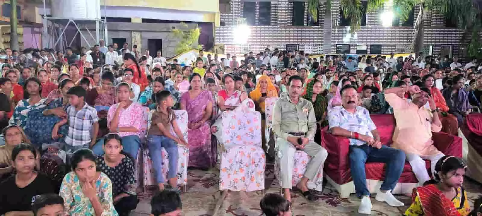 तस्वीर में दिख रही सभा में लोग कुर्सियों पर बैठकर कार्यक्रम देख रहे हैं। तस्वीर में दिख रही सभा में लोग कुर्सियों पर बैठकर कार्यक्रम देख रहे हैं।