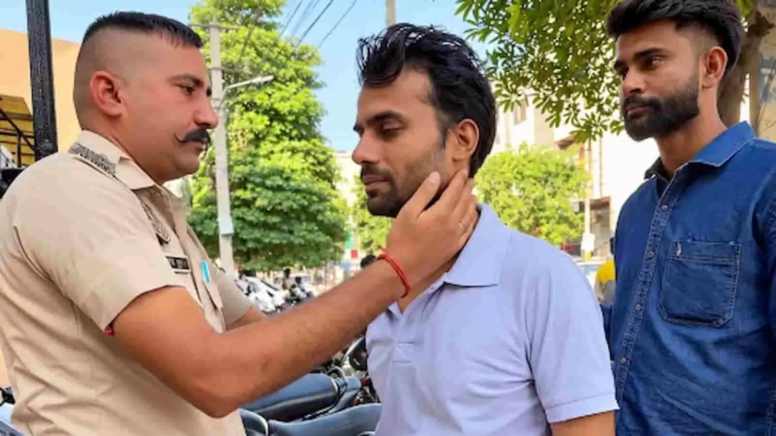 तस्वीर में पुलिसकर्मी एक व्यक्ति की जाँच करता हुआ नजर आ रहा है। तस्वीर में पुलिसकर्मी एक व्यक्ति की जाँच करता हुआ नजर आ रहा है।