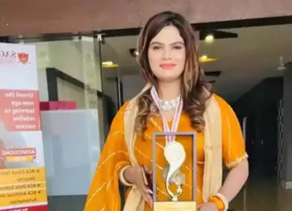 तस्वीर में पीले रंग के पारंपरिक वस्त्र और गले में हार तथा मेडल पहने हुई एक महिला दिखाई दे रही हैं। तस्वीर में पीले रंग के पारंपरिक वस्त्र और गले में हार तथा मेडल पहने हुई एक महिला दिखाई दे रही हैं।