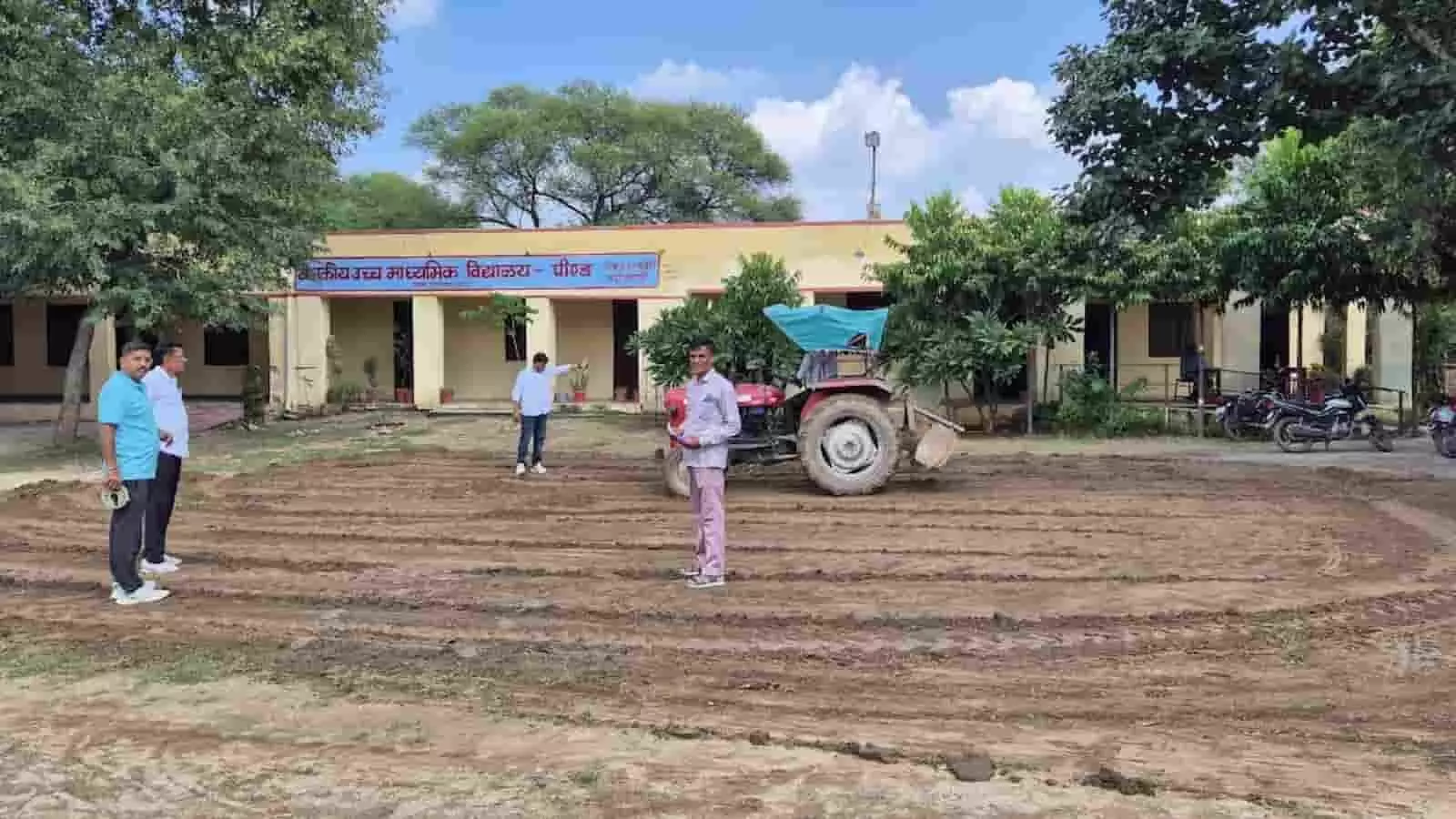 तस्वीर में स्कूल के मैदान में ट्रैक्टर और खड़े हुए लोग दिख रहे हैं। तस्वीर में स्कूल के मैदान में ट्रैक्टर और खड़े हुए लोग दिख रहे हैं।