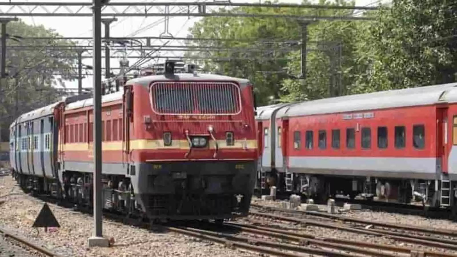 तस्वीर में रेलवे ट्रैक पर खड़ी ट्रेन और उसका इंजन दिखाई दे रहा है। तस्वीर में रेलवे ट्रैक पर खड़ी ट्रेन और उसका इंजन दिखाई दे रहा है।