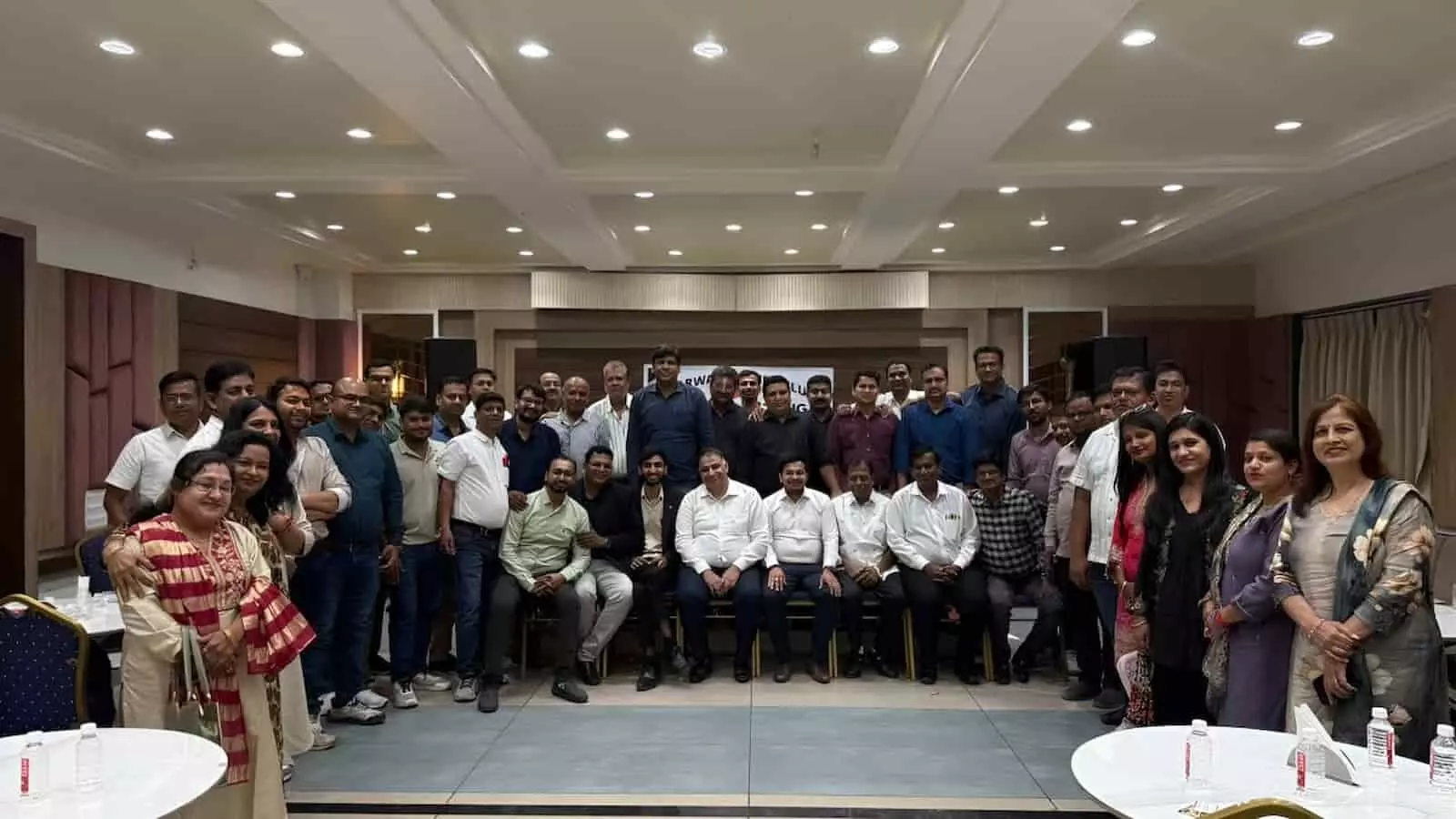तस्वीर में एक सभागार के भीतर बड़ी संख्या में पुरुष और महिलाएं एक साथ खड़े होकर समूह में नजर आ रहे हैं। तस्वीर में एक सभागार के भीतर बड़ी संख्या में पुरुष और महिलाएं एक साथ खड़े होकर समूह में नजर आ रहे हैं।